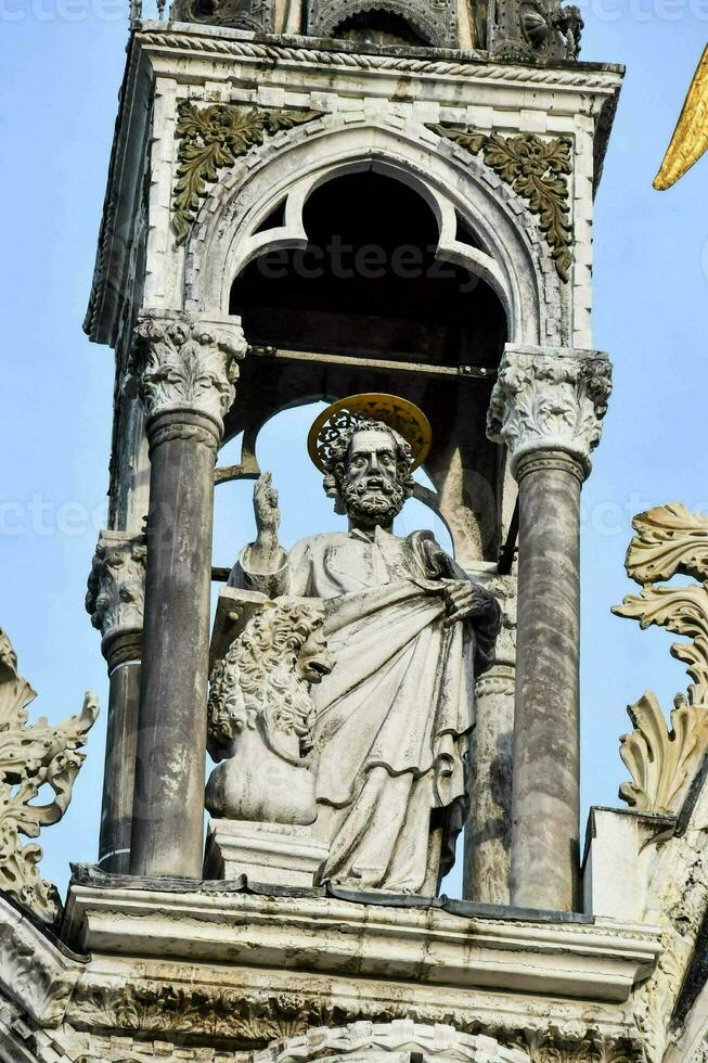 statue of saint peter on the bell tower of the cathedral photo
