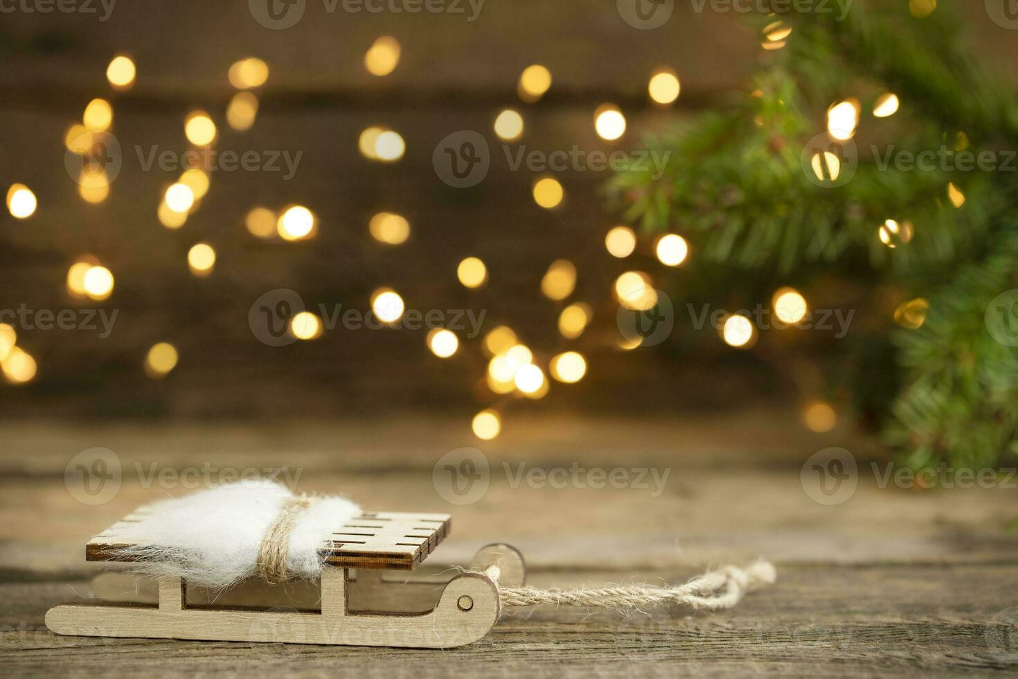 Winter sledge on wooden Christmas background with defocused lights photo