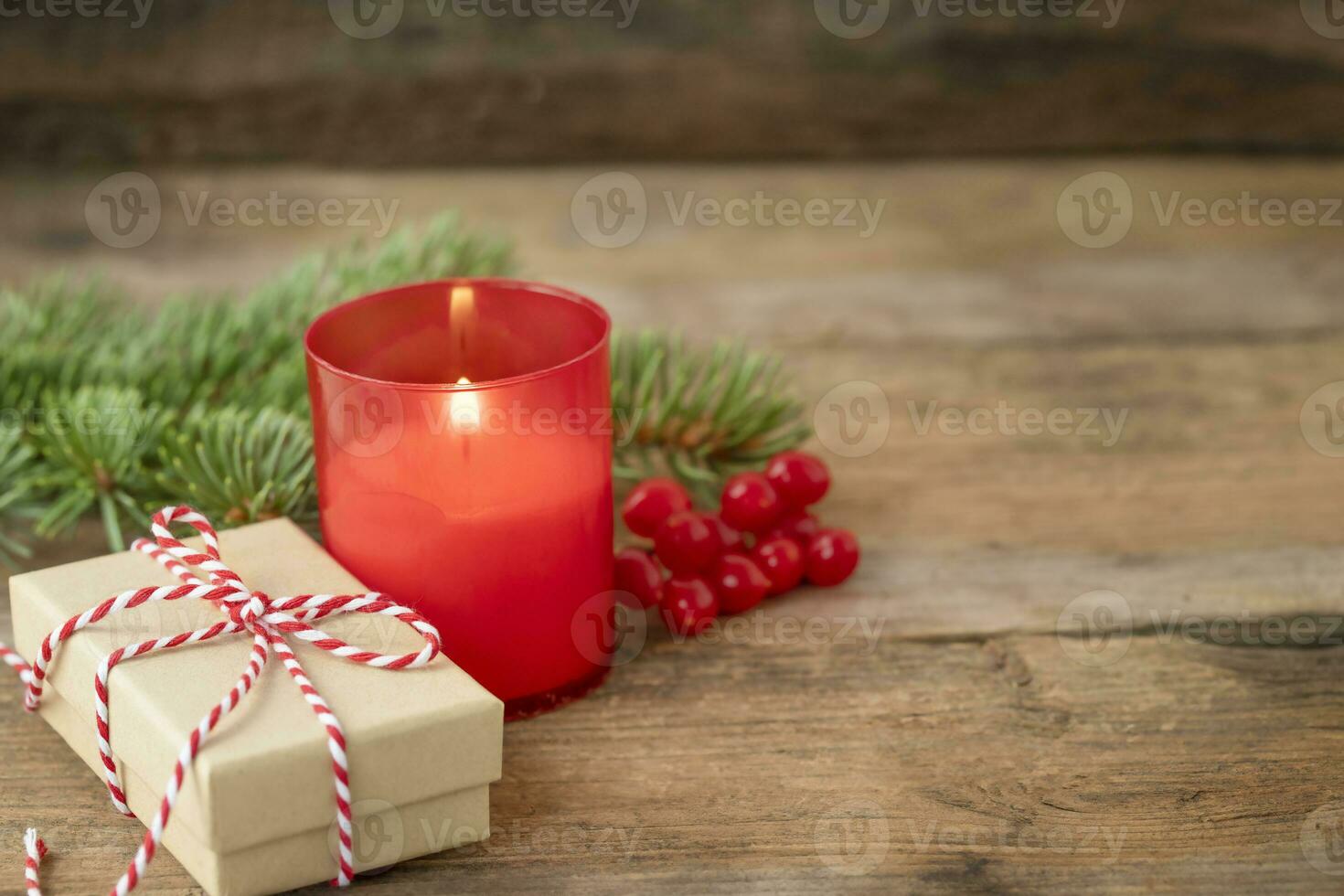 Christmas composition with candle, gift box and spruce twig on wooden background photo