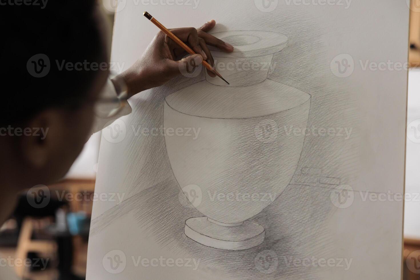 African American guy student improving drawing skills, attending art workshop. Closeup of man holding pencil practicing pencil shading techniques, being focused on process of sketching photo