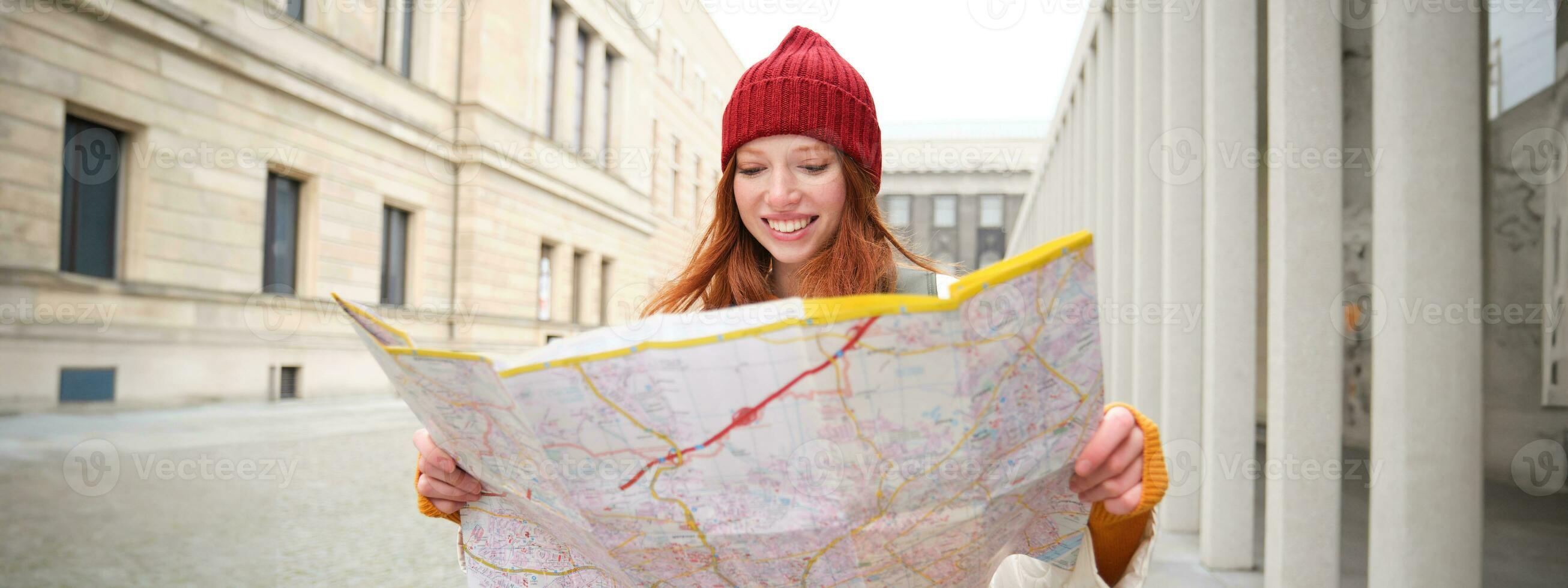 Redhead girl, tourist explores city, looks at paper map to find way for historical landmarks, woman on her trip around euope searches for sightseeing photo