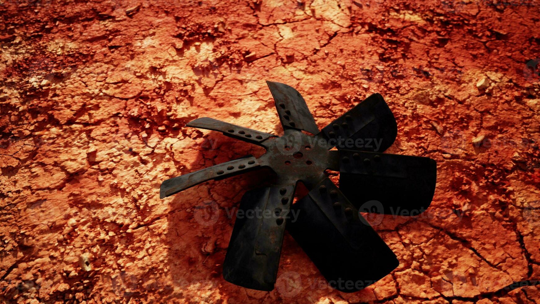 A propeller on a vibrant red dirt field photo