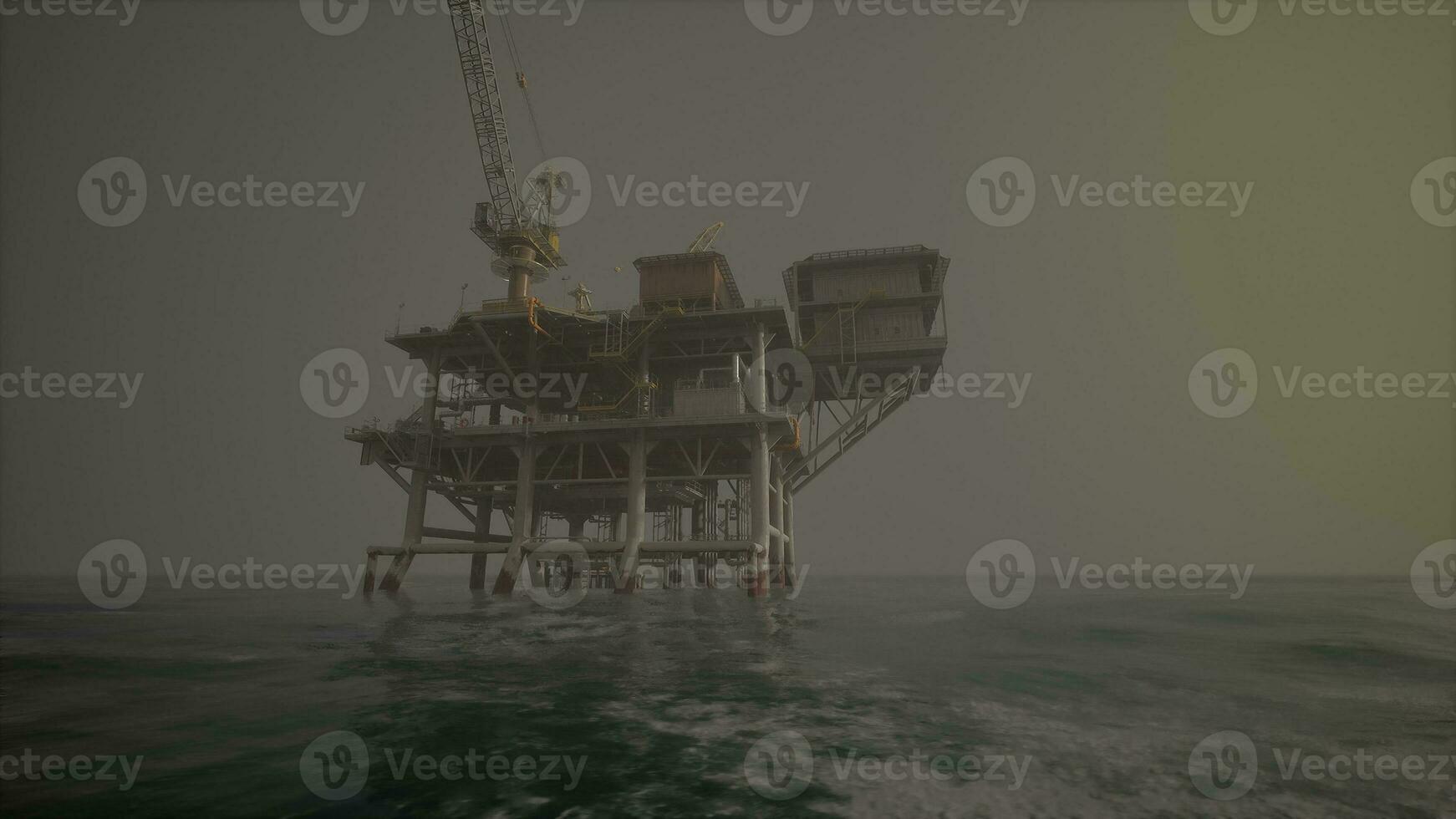 An oil rig standing tall in the middle of the vast ocean photo