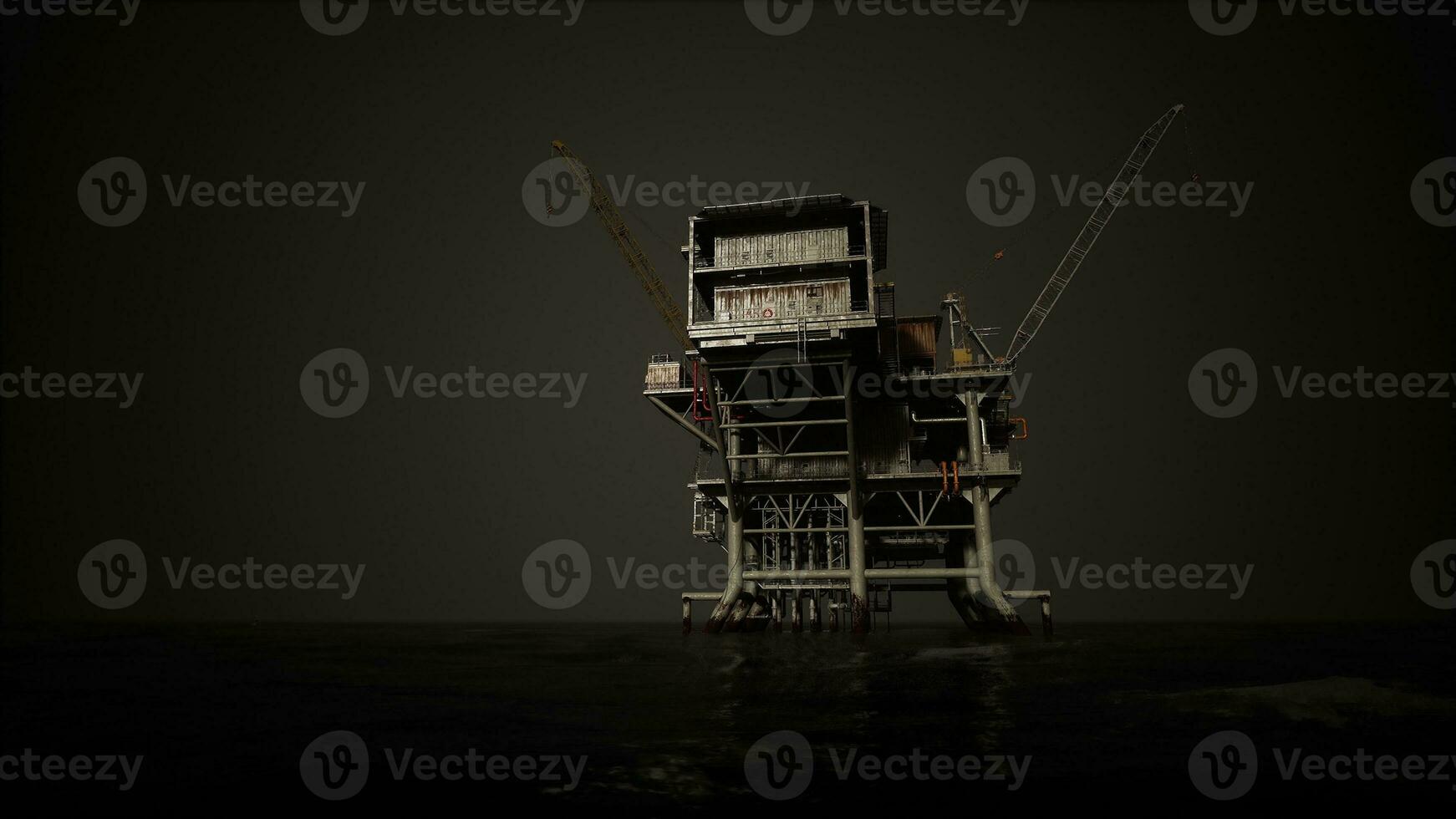 A towering oil rig in the middle of the ocean photo