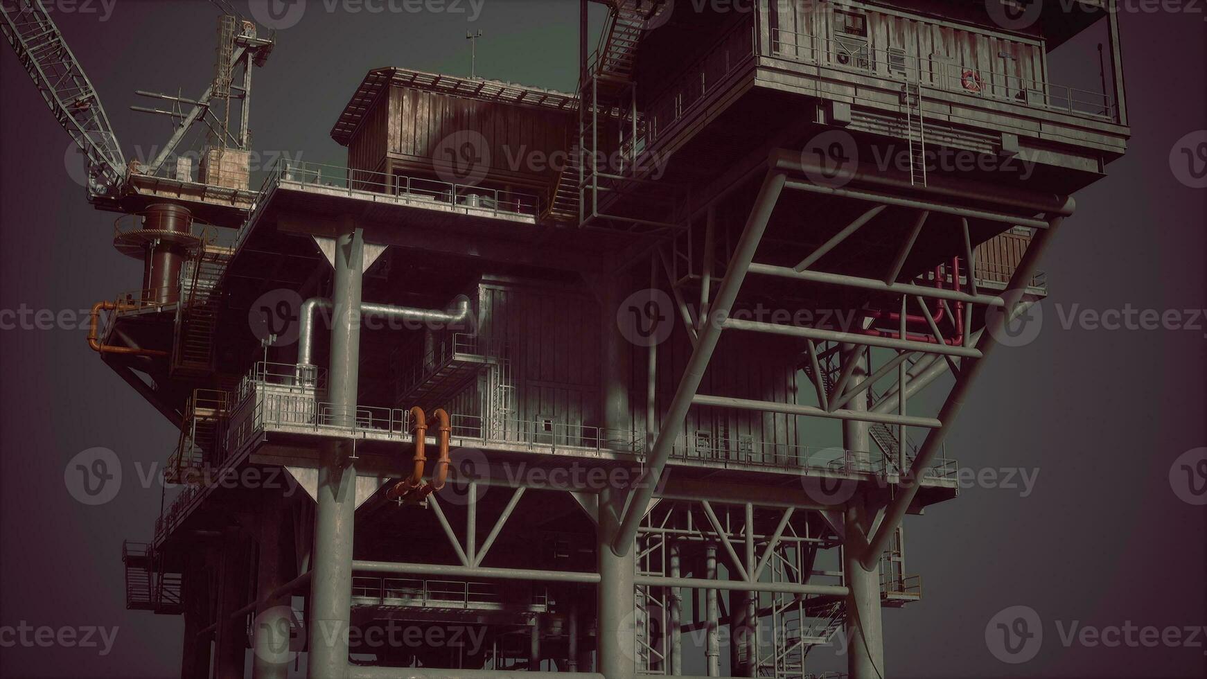 An oil rig towering over the ocean with a crane on top photo