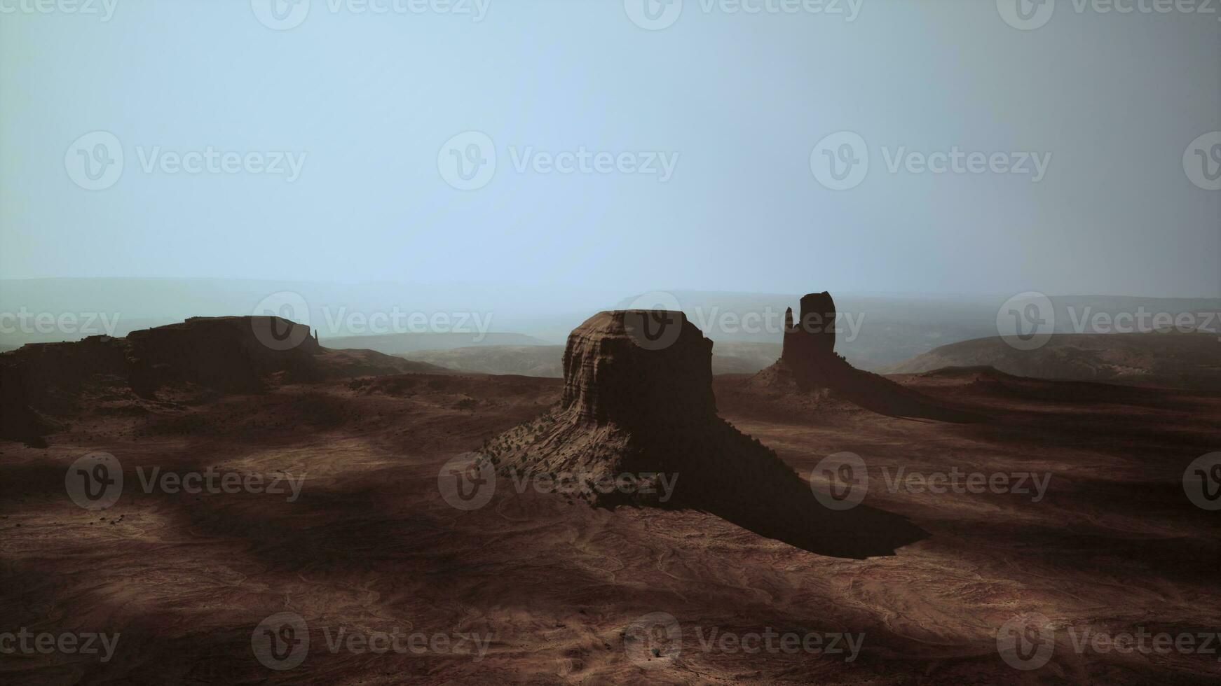 A majestic rock formation rising from the vast desert landscape photo