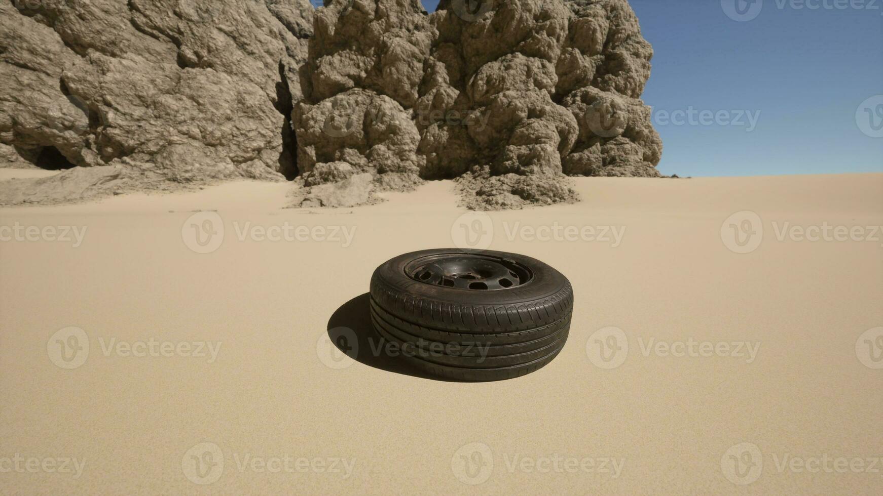 A tire sitting in the middle of a desert photo