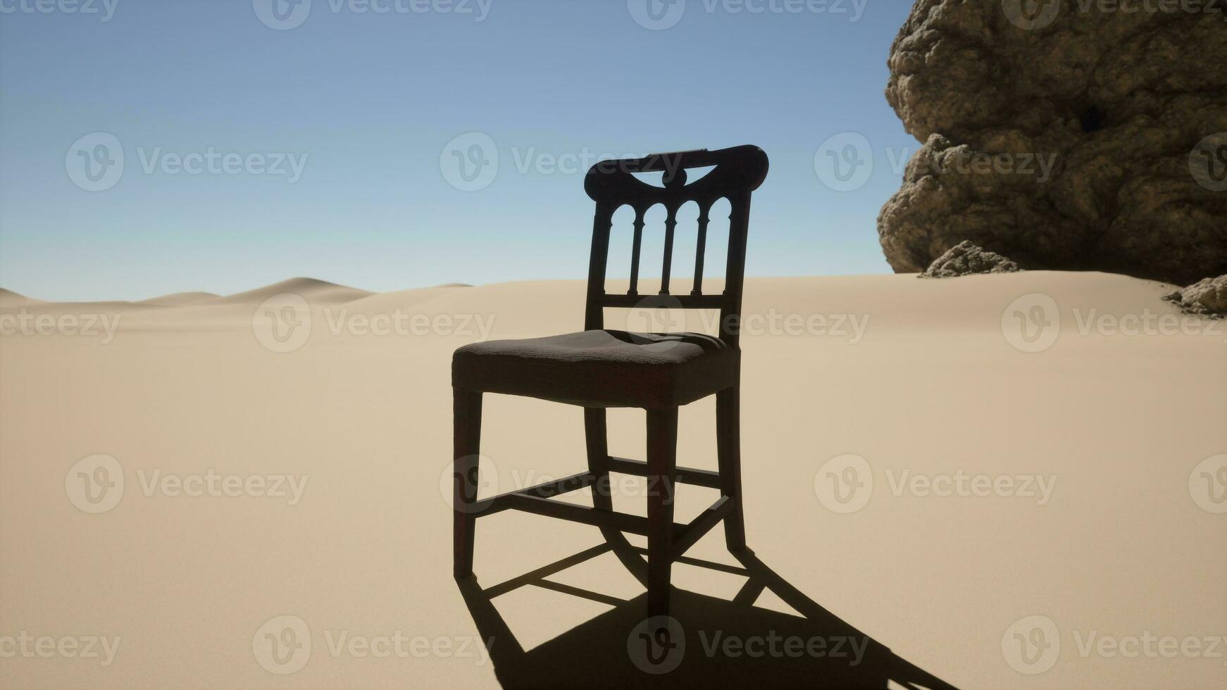 A chair sitting in the middle of a desert photo