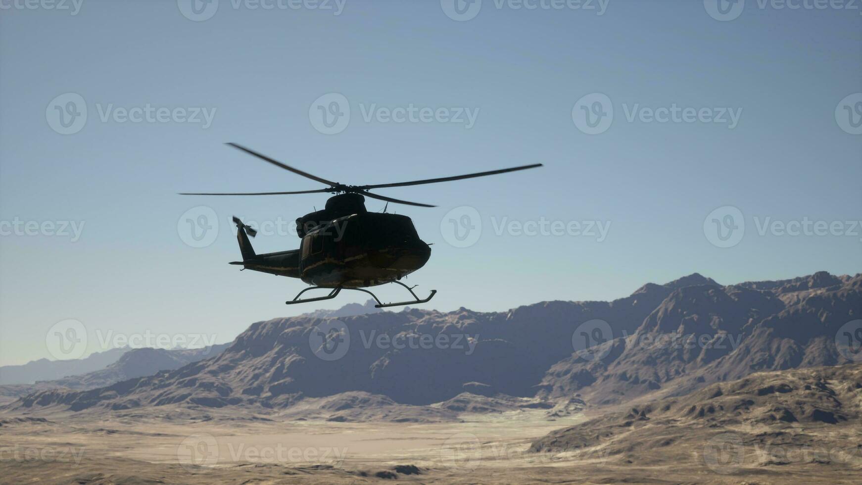 A helicopter flying over a mountain range in the desert photo