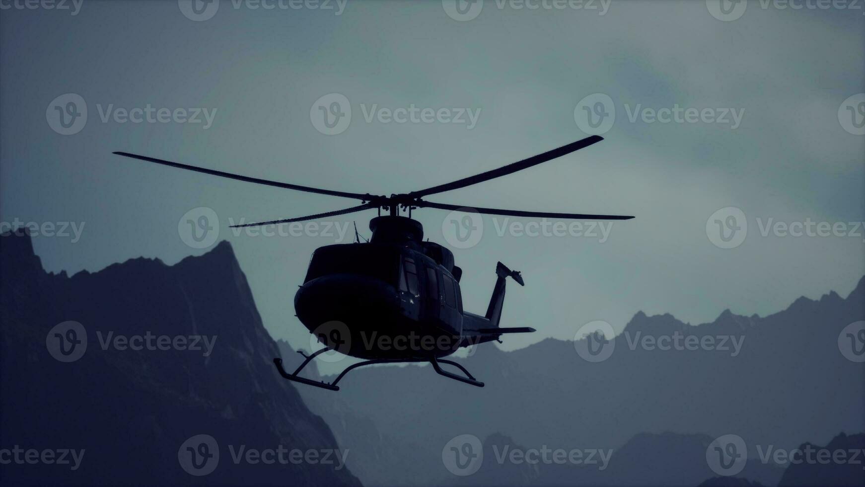 A black helicopter flying over a mountain range photo