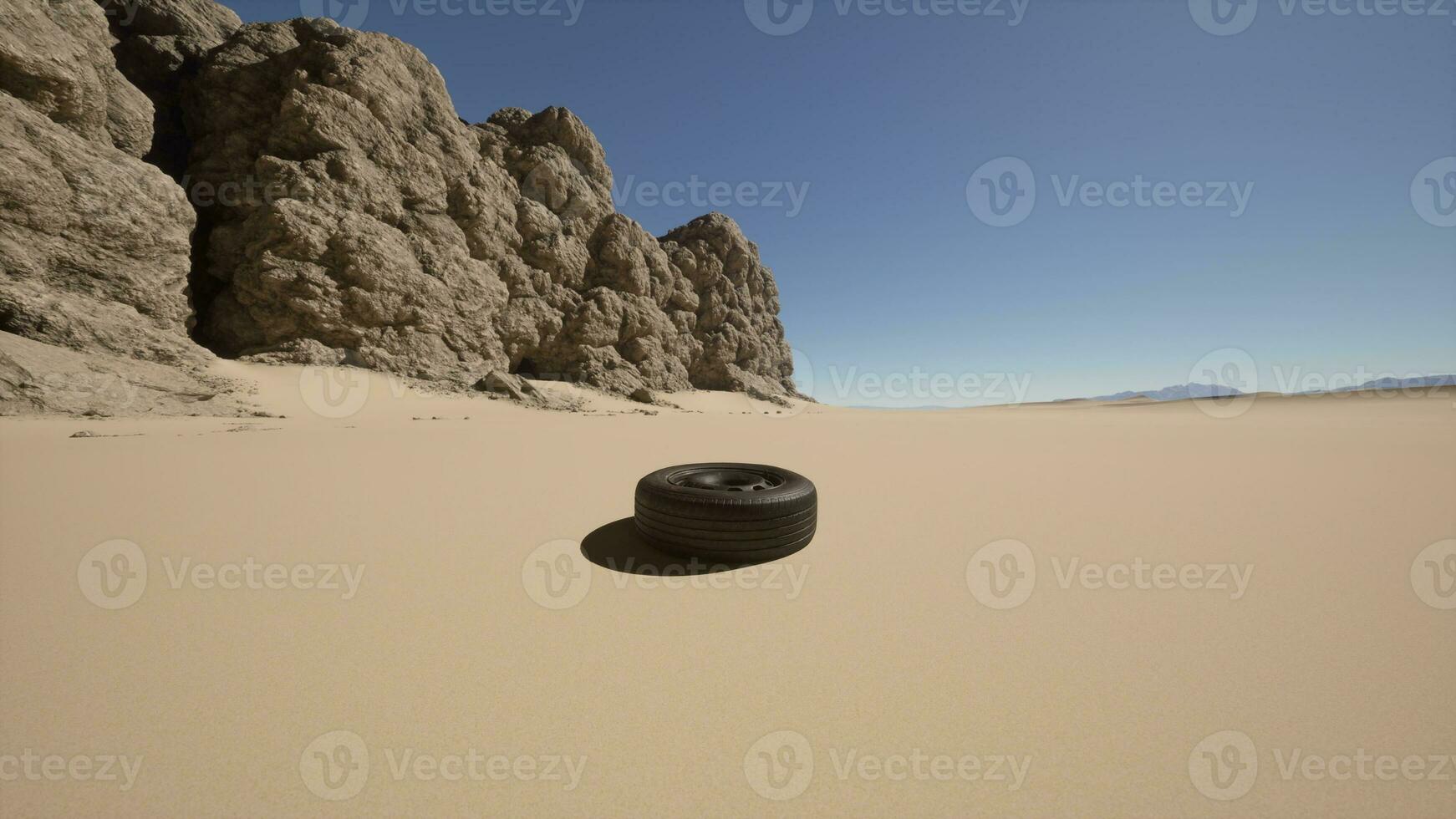 A tire sitting in the middle of a desert photo