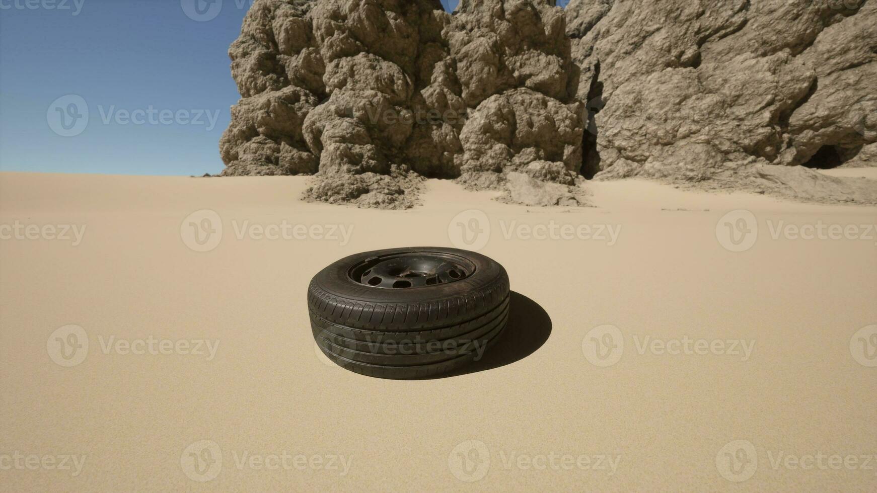 A tire sitting in the middle of a desert photo