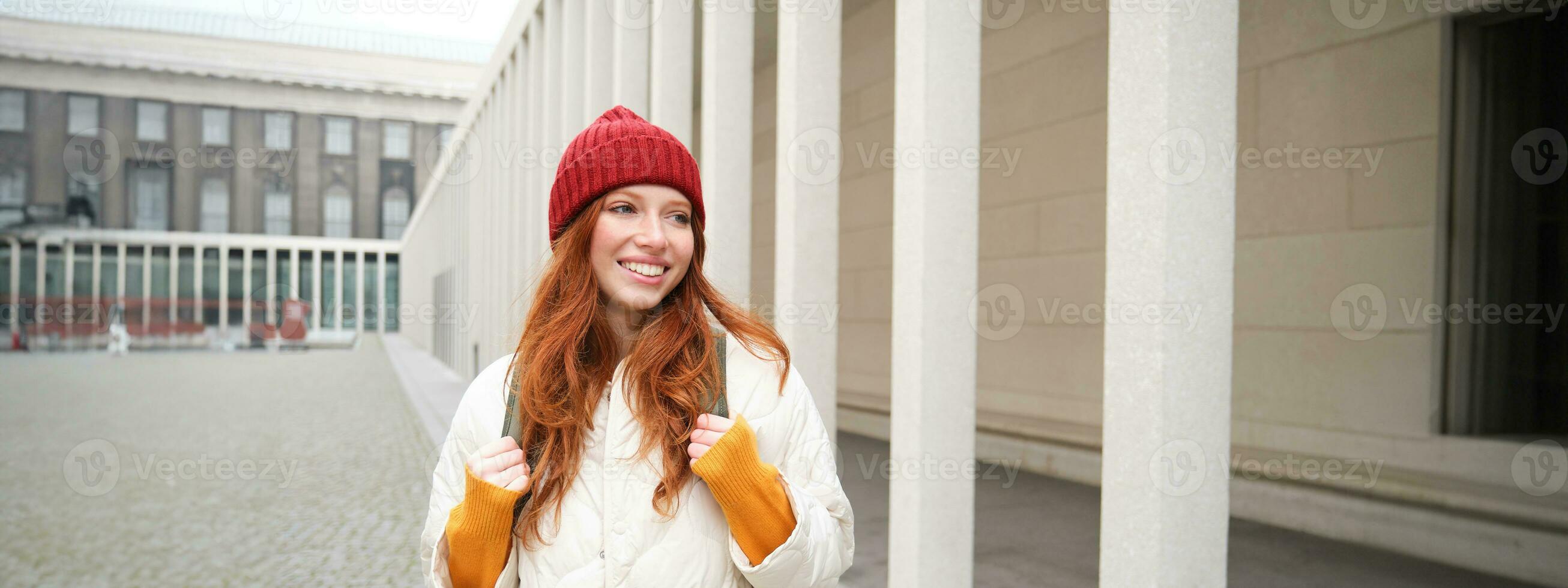 Happy redhead girl, tourist going around town, exploring sighsteeing places in city, backpacking around europe, enjoys travelling photo