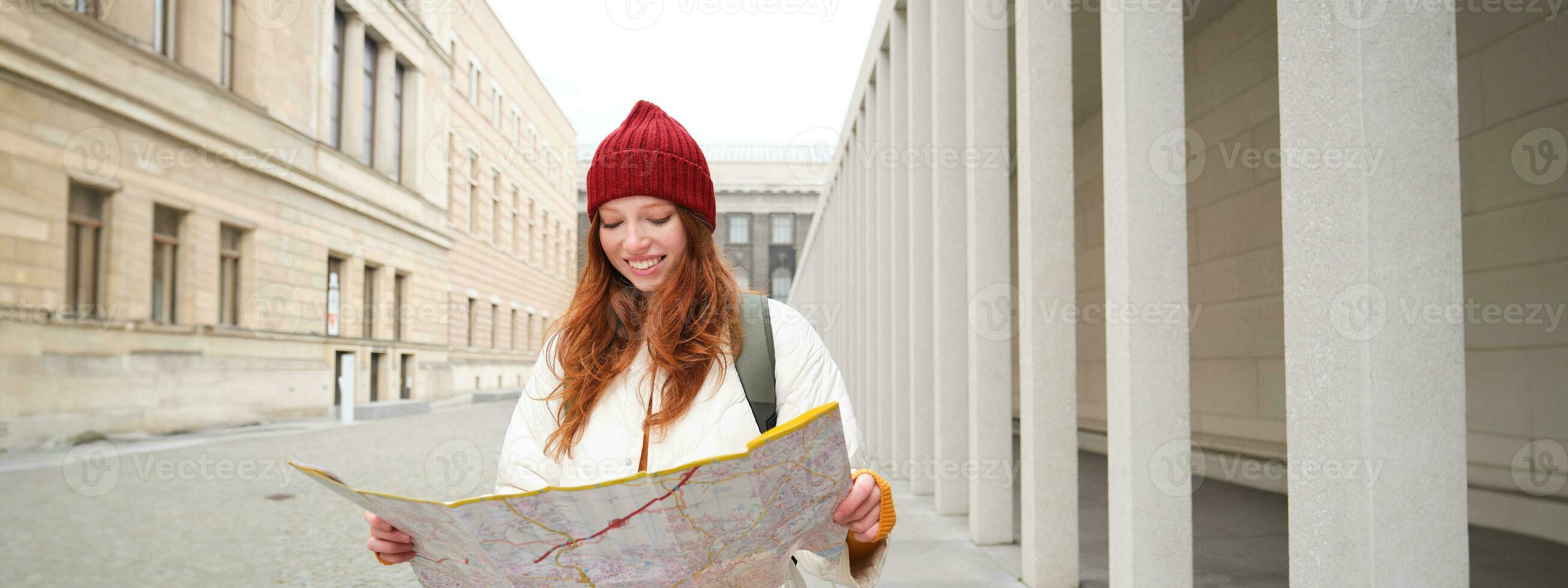 Redhead girl, tourist explores city, looks at paper map to find way for historical landmarks, woman on her trip around euope searches for sightseeing photo