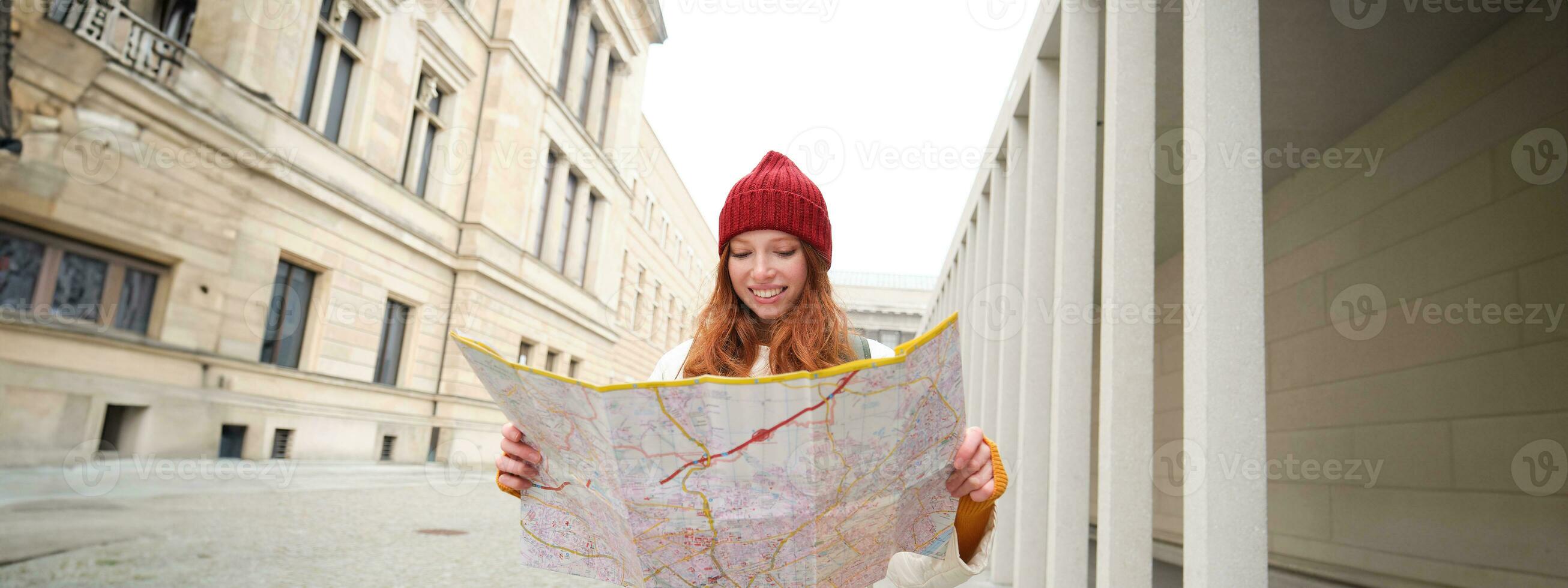 Redhead girl, tourist explores city, looks at paper map to find way for historical landmarks, woman on her trip around euope searches for sightseeing photo