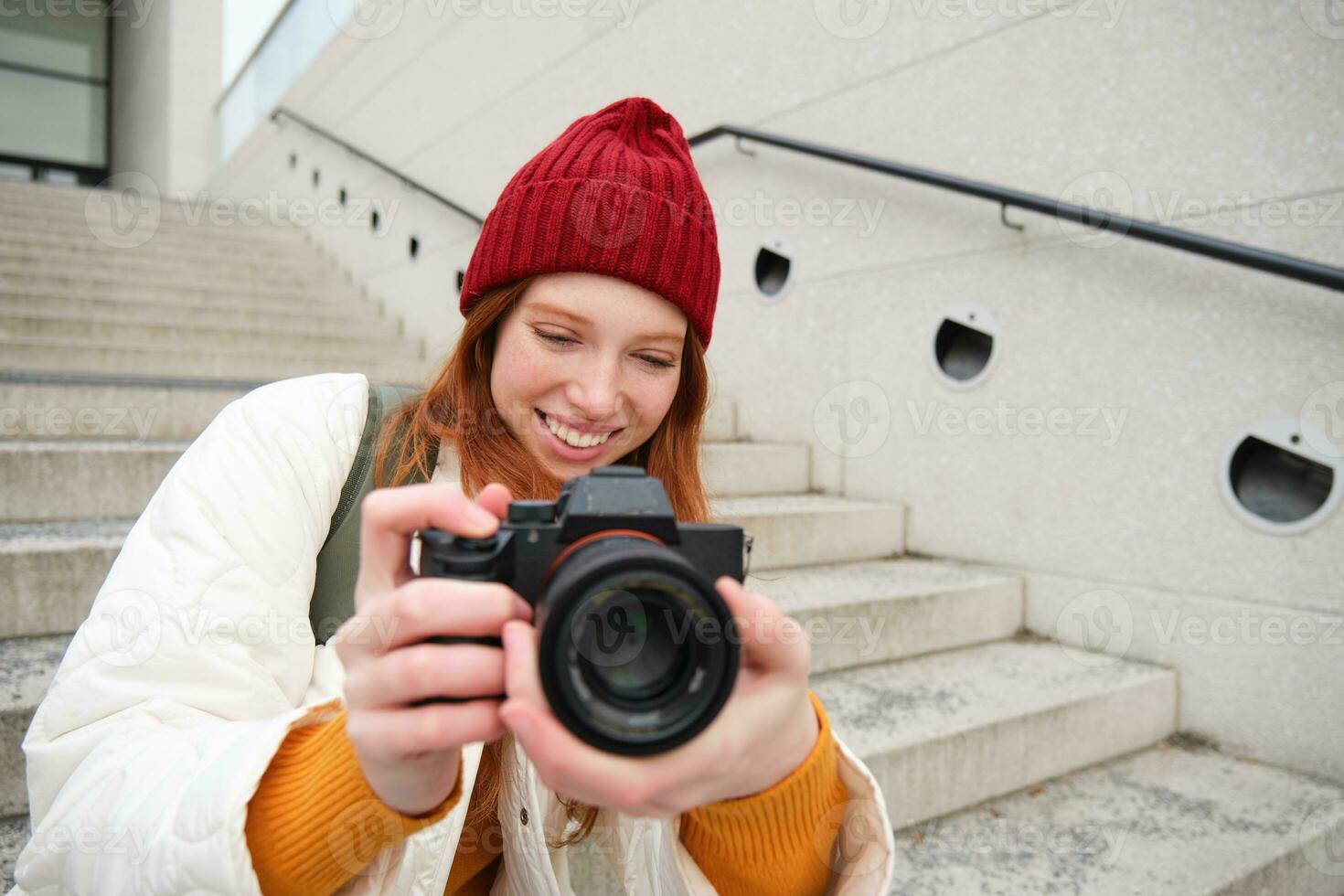 Urban people and lifestyle. Happy redhead woman takes photos, holding professional digital camera, photographing on streets photo