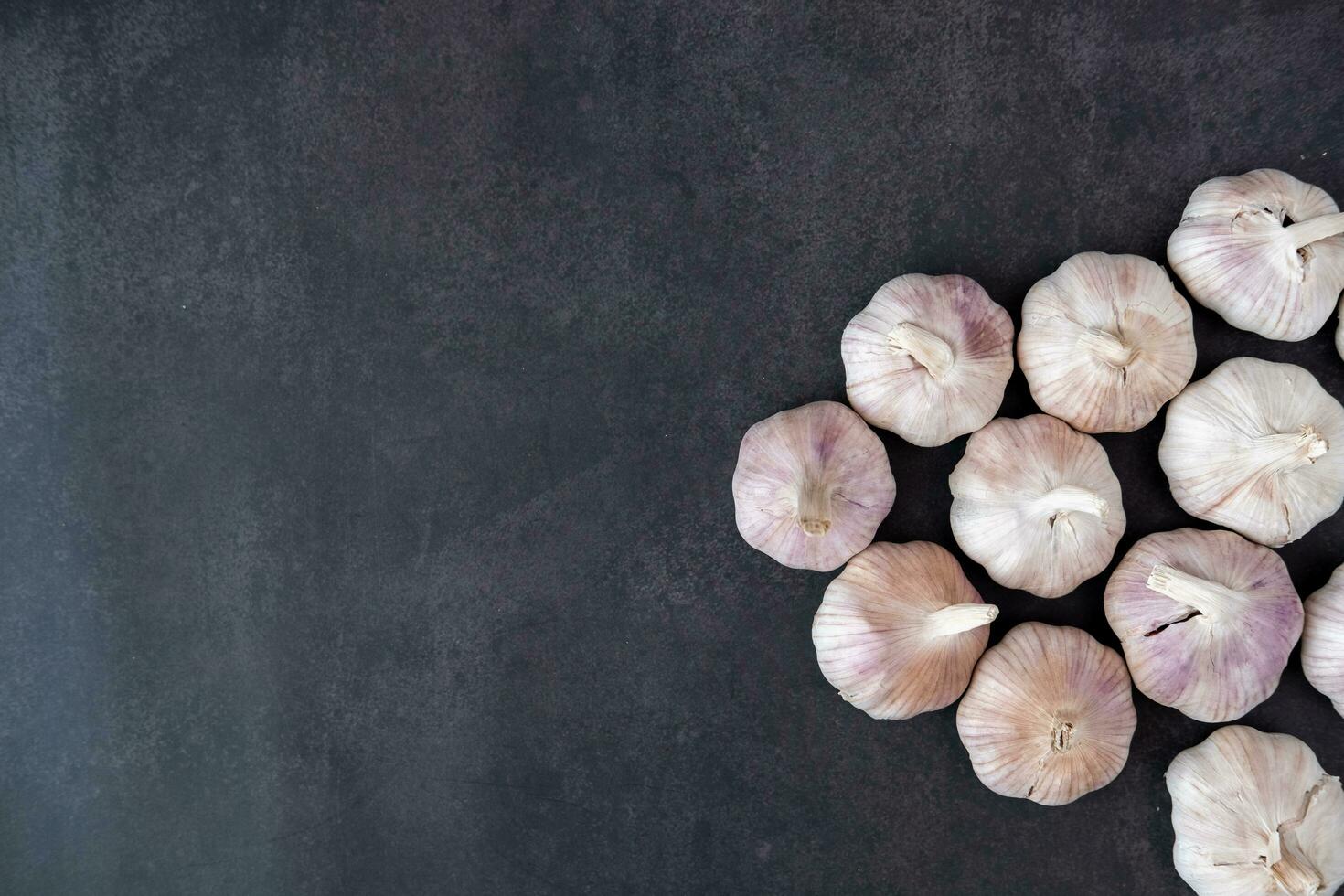 Big and small heads of garlic on a black background. photo