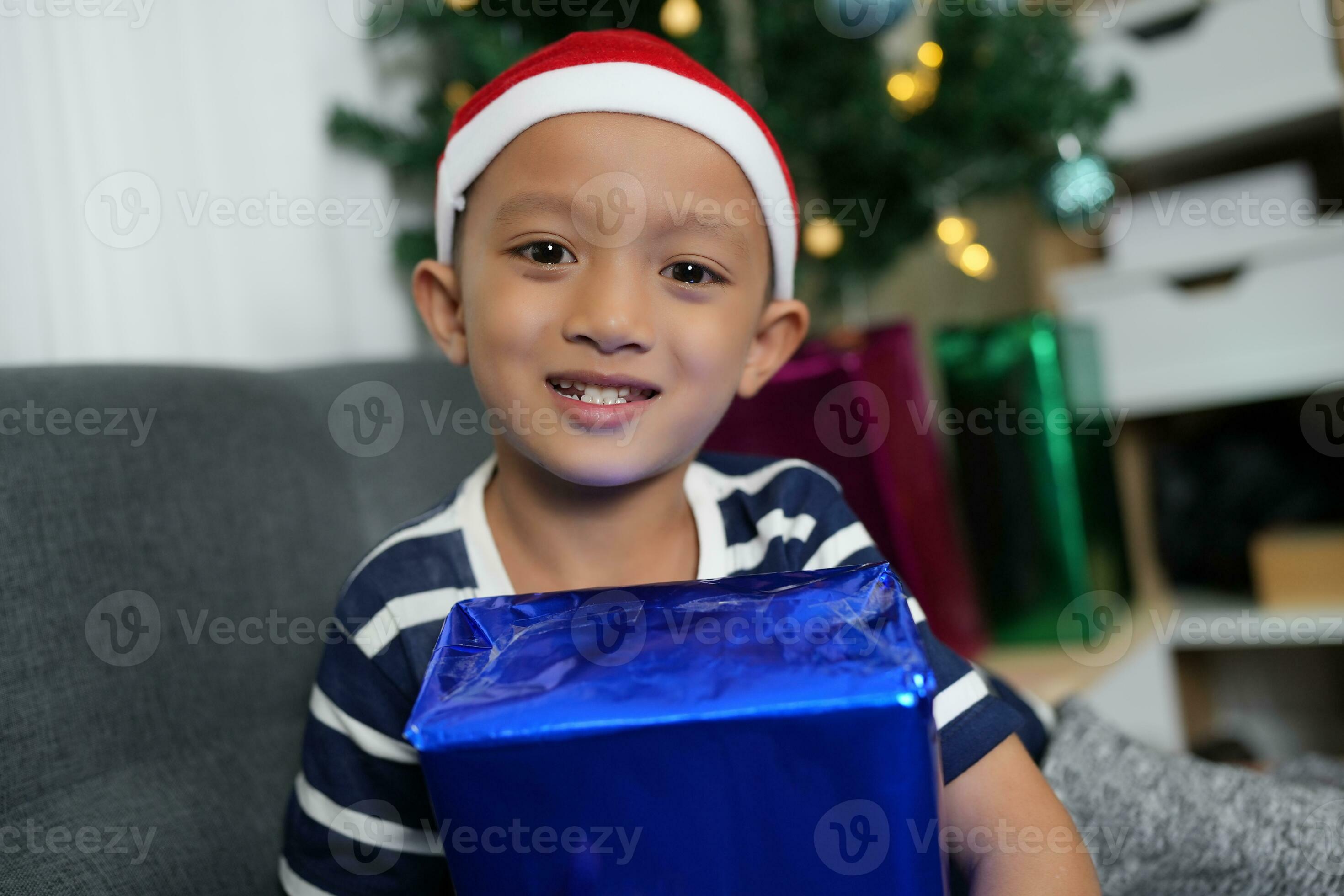 Merry Christmas 2024 concept A boy holding a gift box is happy to