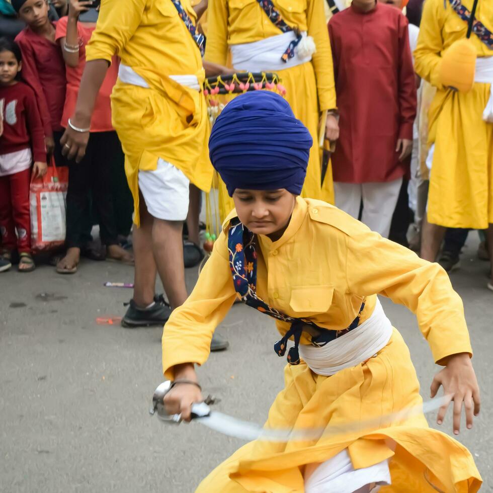 Delhi, India, October 2, 2023 - Sikhs display gatka and martial arts during annual Nagar Kirtan, Traditional, procession on account of birthday of Guru Nanak Dev ji, Nagar Kirtan in East Delhi area photo