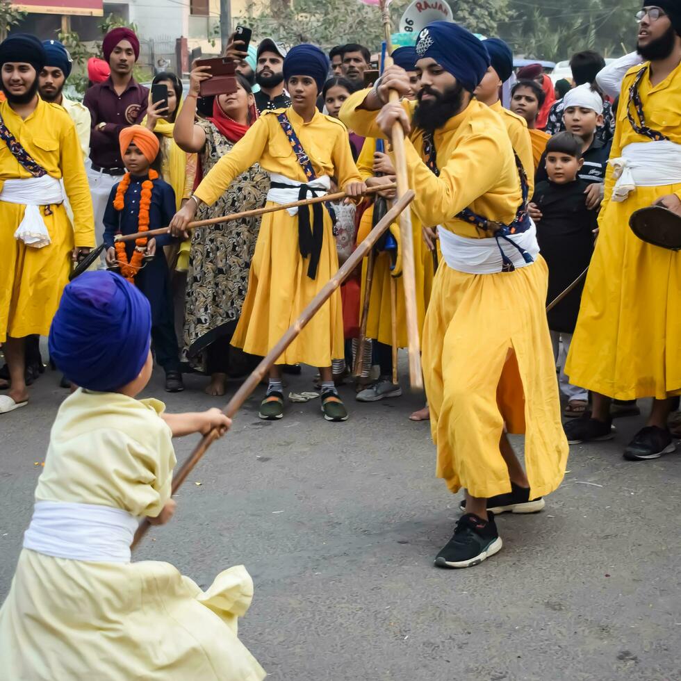 Delhi, India, October 2, 2023 - Sikhs display gatka and martial arts during annual Nagar Kirtan, Traditional, procession on account of birthday of Guru Nanak Dev ji, Nagar Kirtan in East Delhi area photo