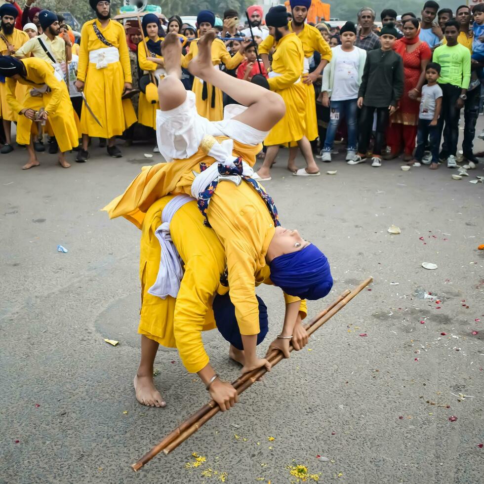 Delhi, India, October 2, 2023 - Sikhs display gatka and martial arts during annual Nagar Kirtan, Traditional, procession on account of birthday of Guru Nanak Dev ji, Nagar Kirtan in East Delhi area photo