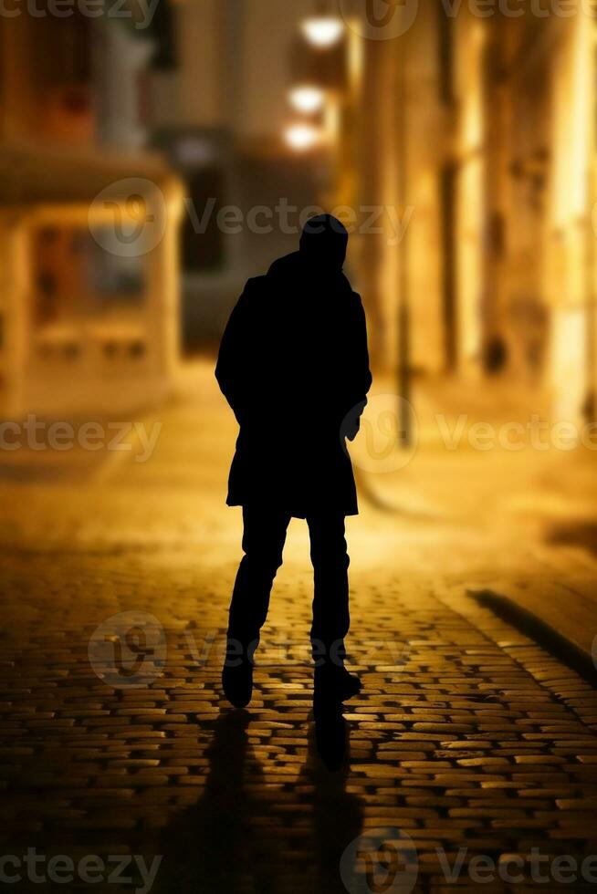 the mysterious figure of a man on a deserted street of the old city in the light of lanterns.selective focus . High quality photo