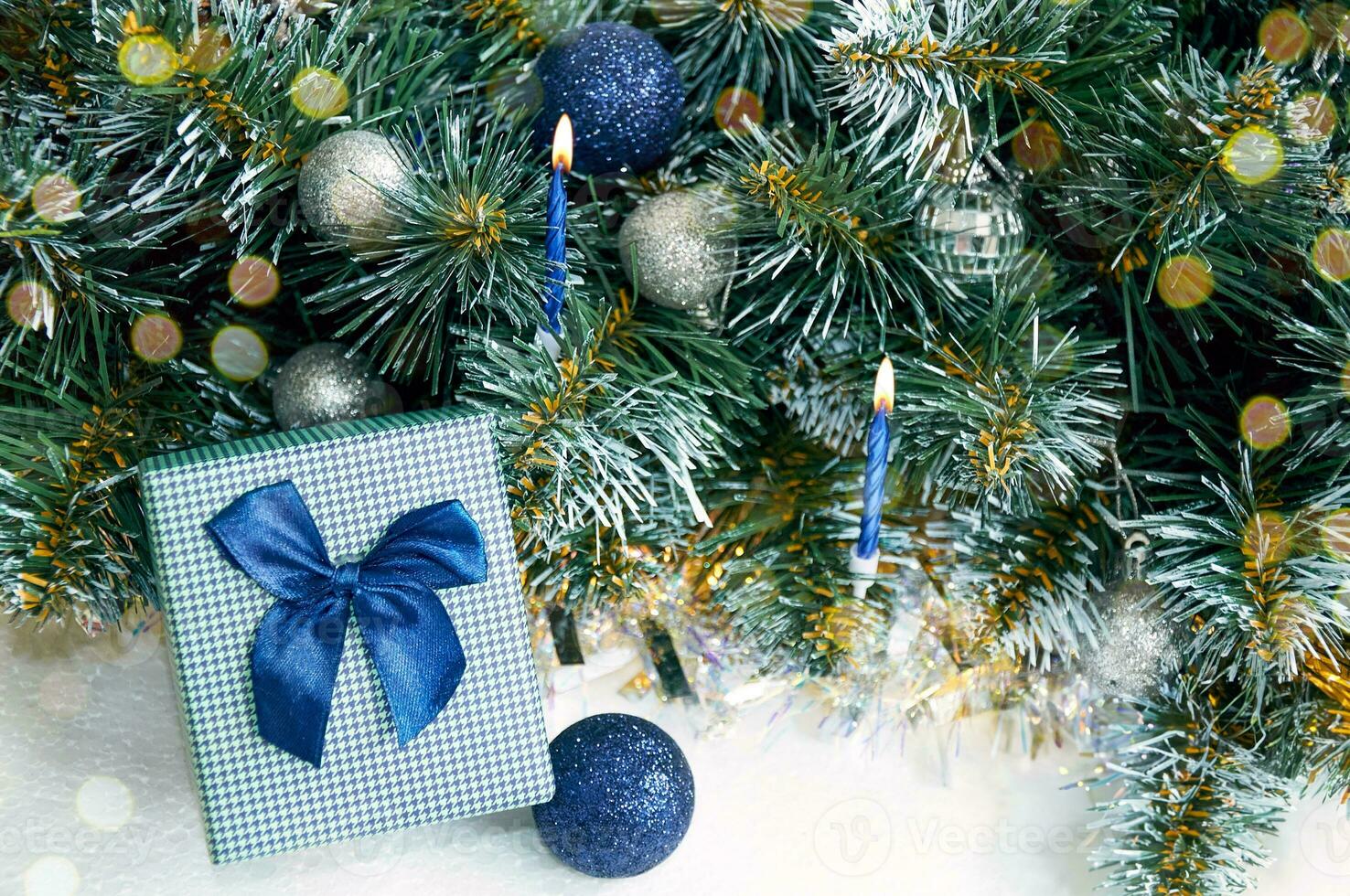 Christmas composition with Christmas tree branches in blue and silver balls and blue gift box photo