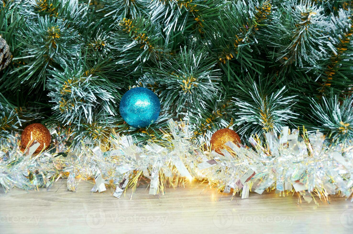 Christmas background with Christmas tree branches, blue and yellow layers and silver tinsel on a wooden background. Copy space for text photo