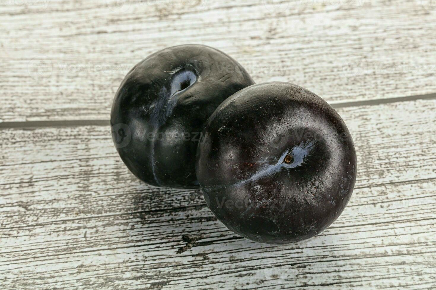 Two ripe sweet black plums photo