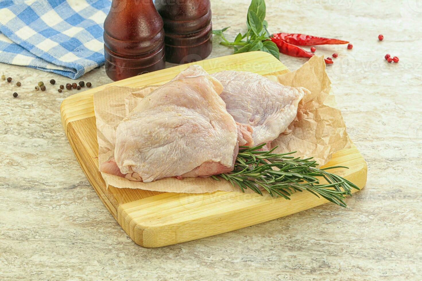 Raw chicken thighs over board photo