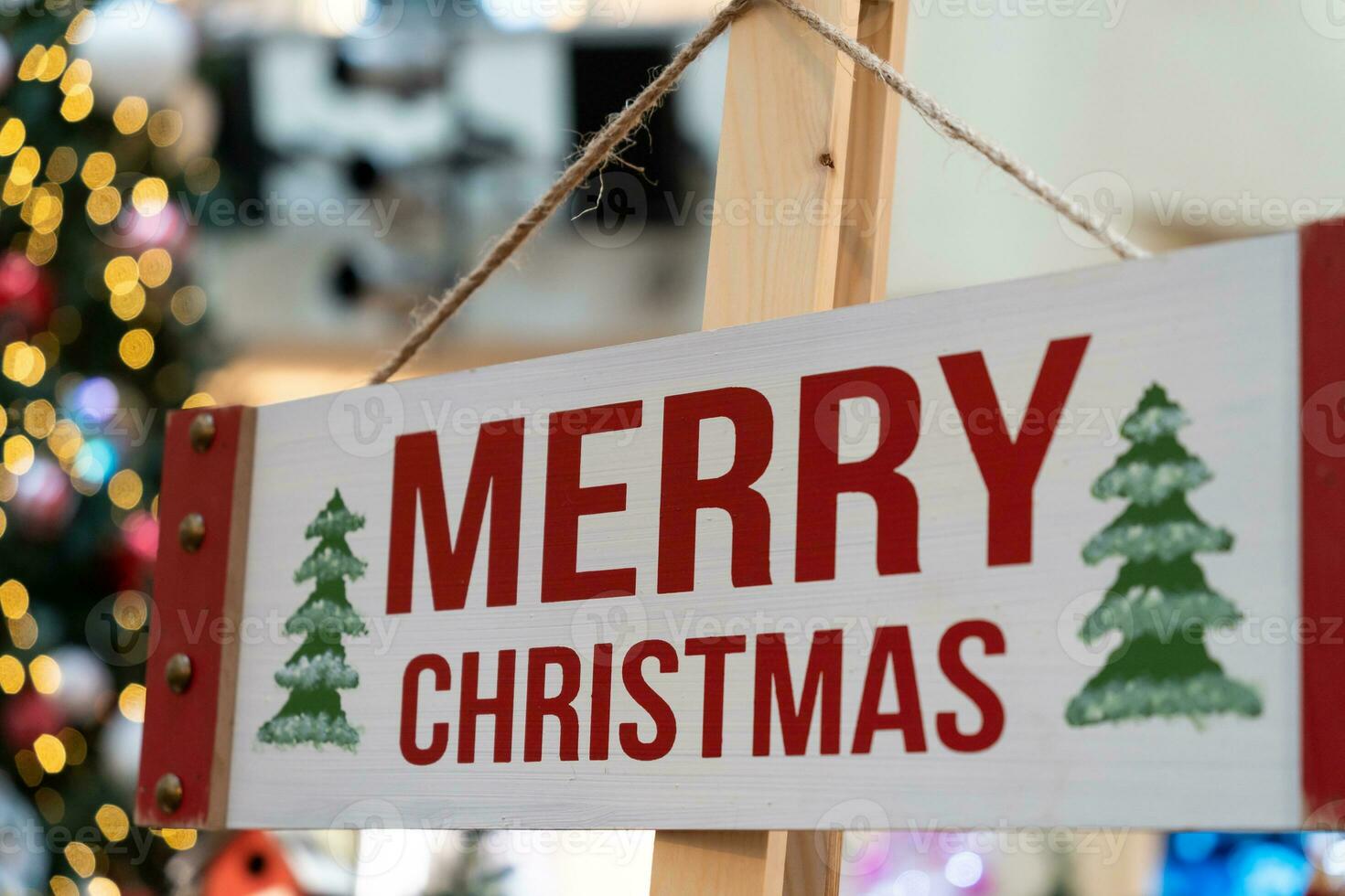 Wood Merry Christmas sign hanging on the timber column. photo