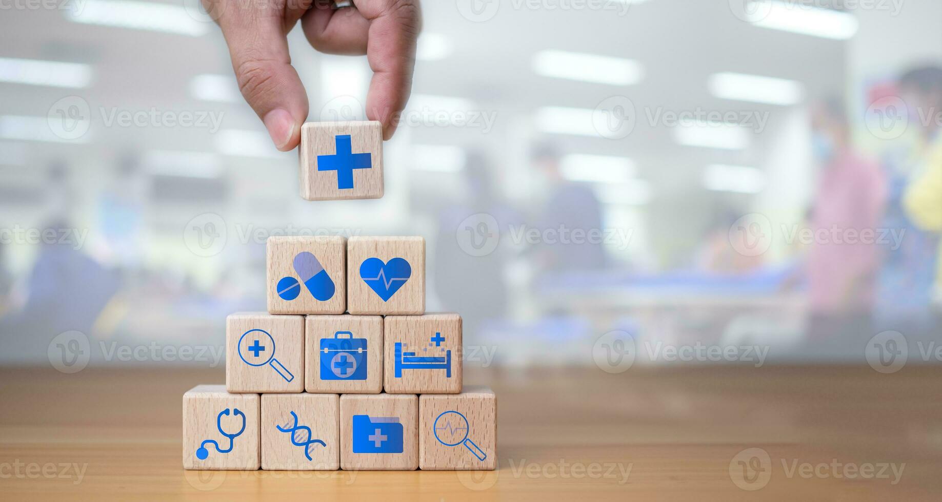 Health insurance and healthcare concept, human hand holds wooden block with icons about health insurance and healthcare access, retirement planning on wooden background. photo