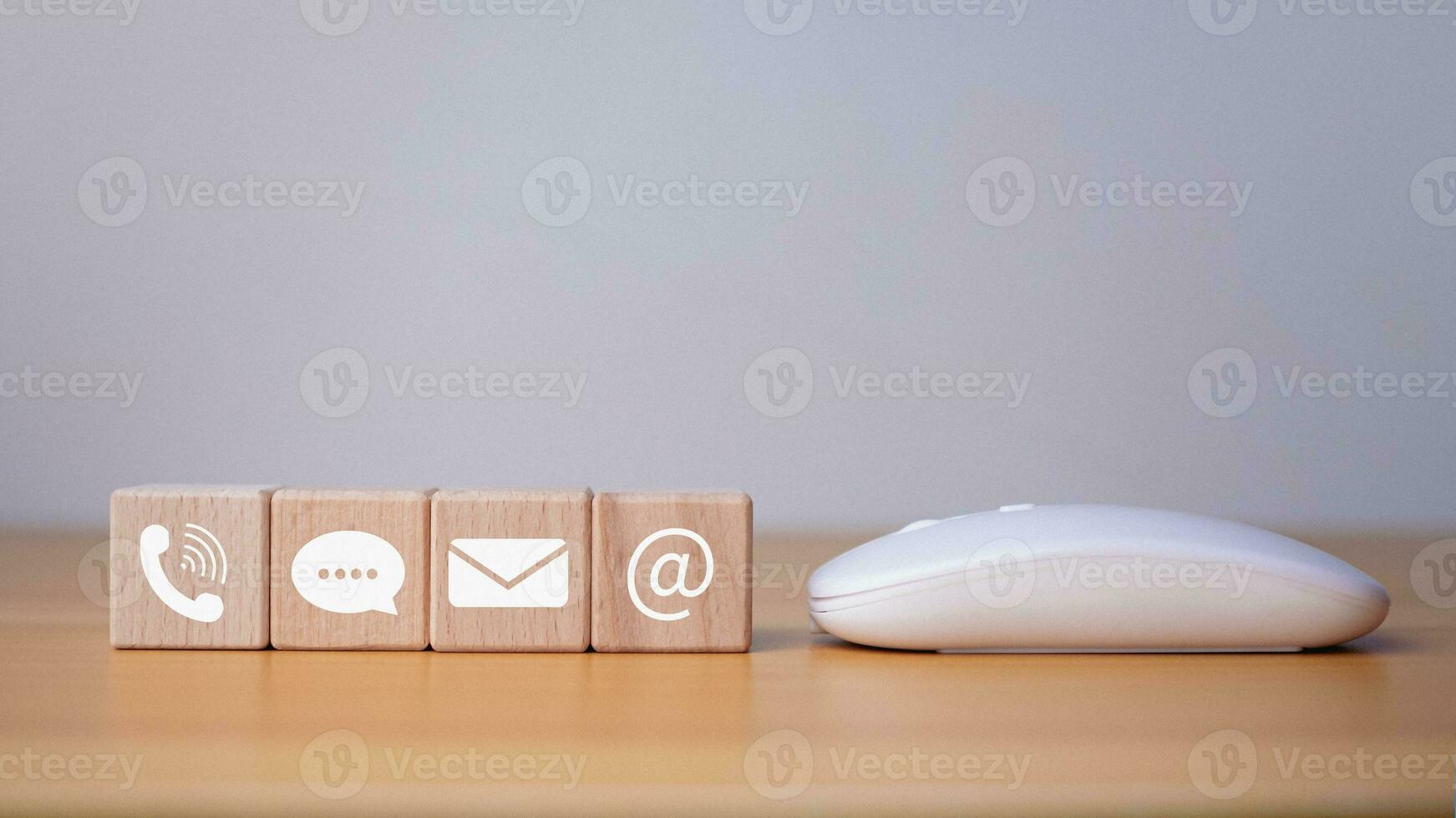 Website page contact us or email marketing concept, customer support hotline, contact us, wooden block printed communication symbol with mouse, email icons, phone, address, chat message. photo