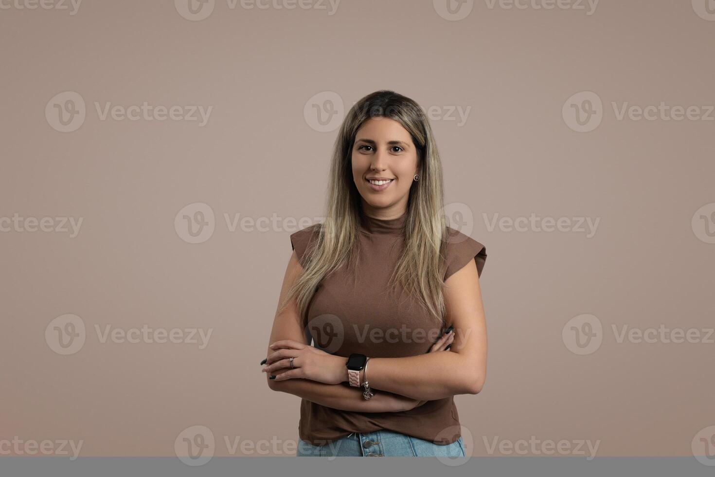 Happy woman with brown hair standing in a studio portrait photo