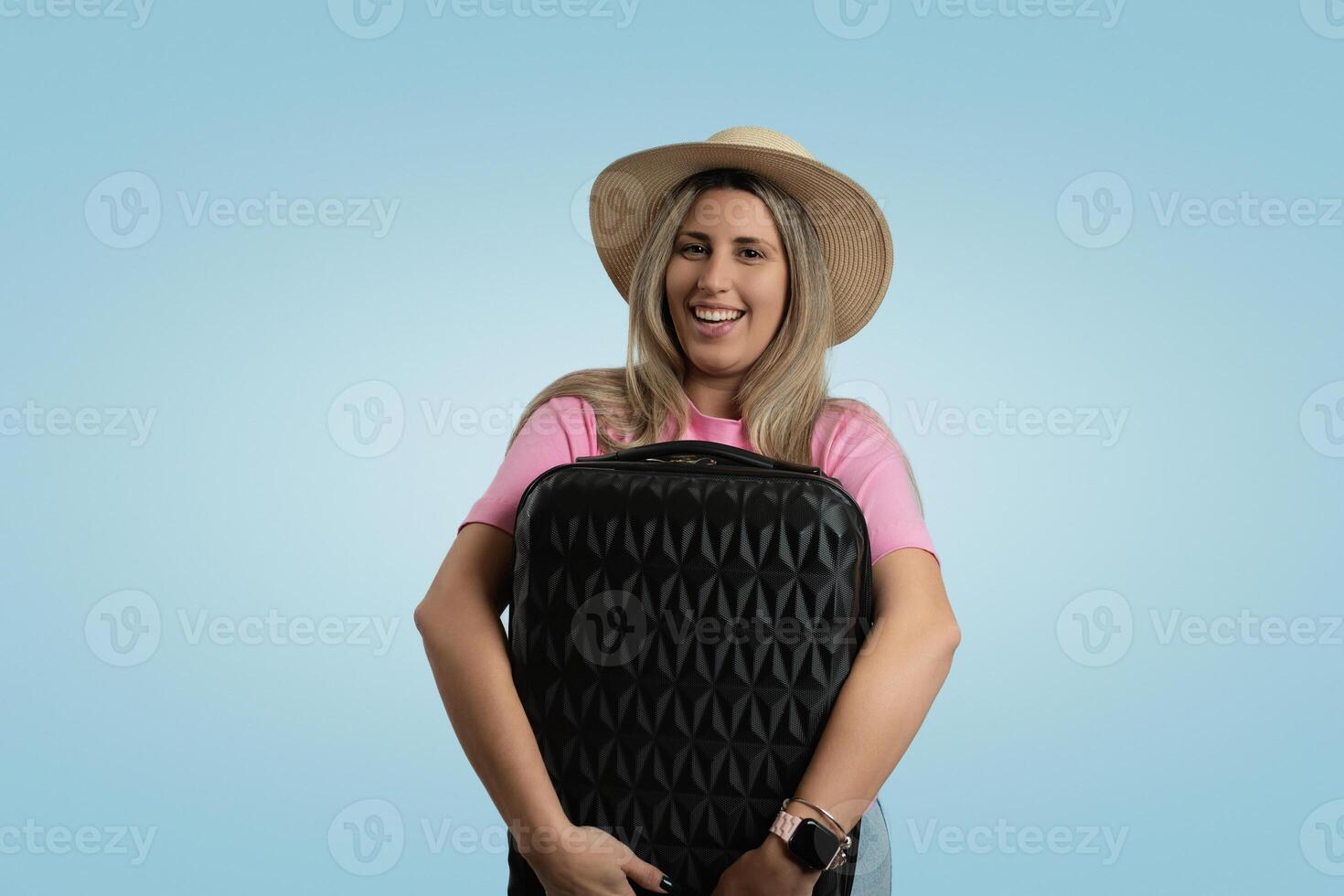 Smiling Woman in Colorful Clothing and Hat Standing in Front of a Blue Backdrop photo