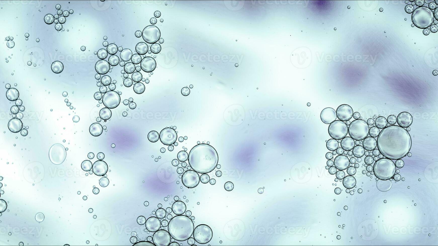 El aceite de comida colorido abstracto cae burbujas y esferas que fluyen en la superficie del agua foto