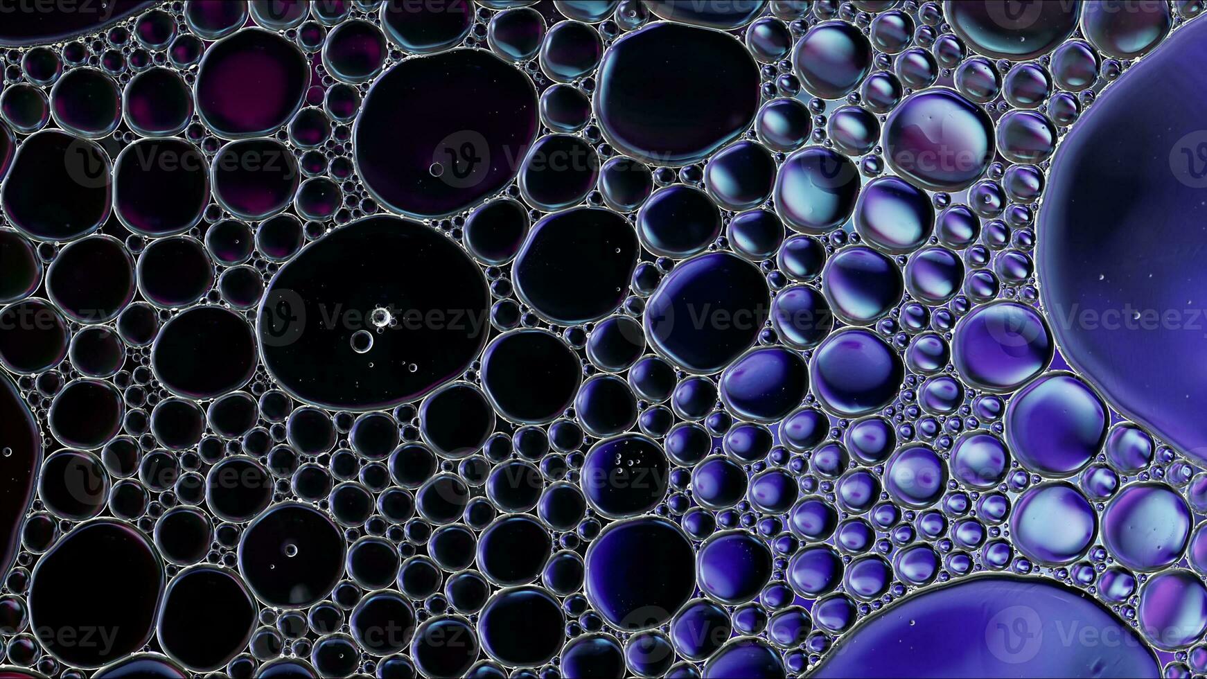 El aceite de comida colorido abstracto cae burbujas y esferas que fluyen en la superficie del agua foto