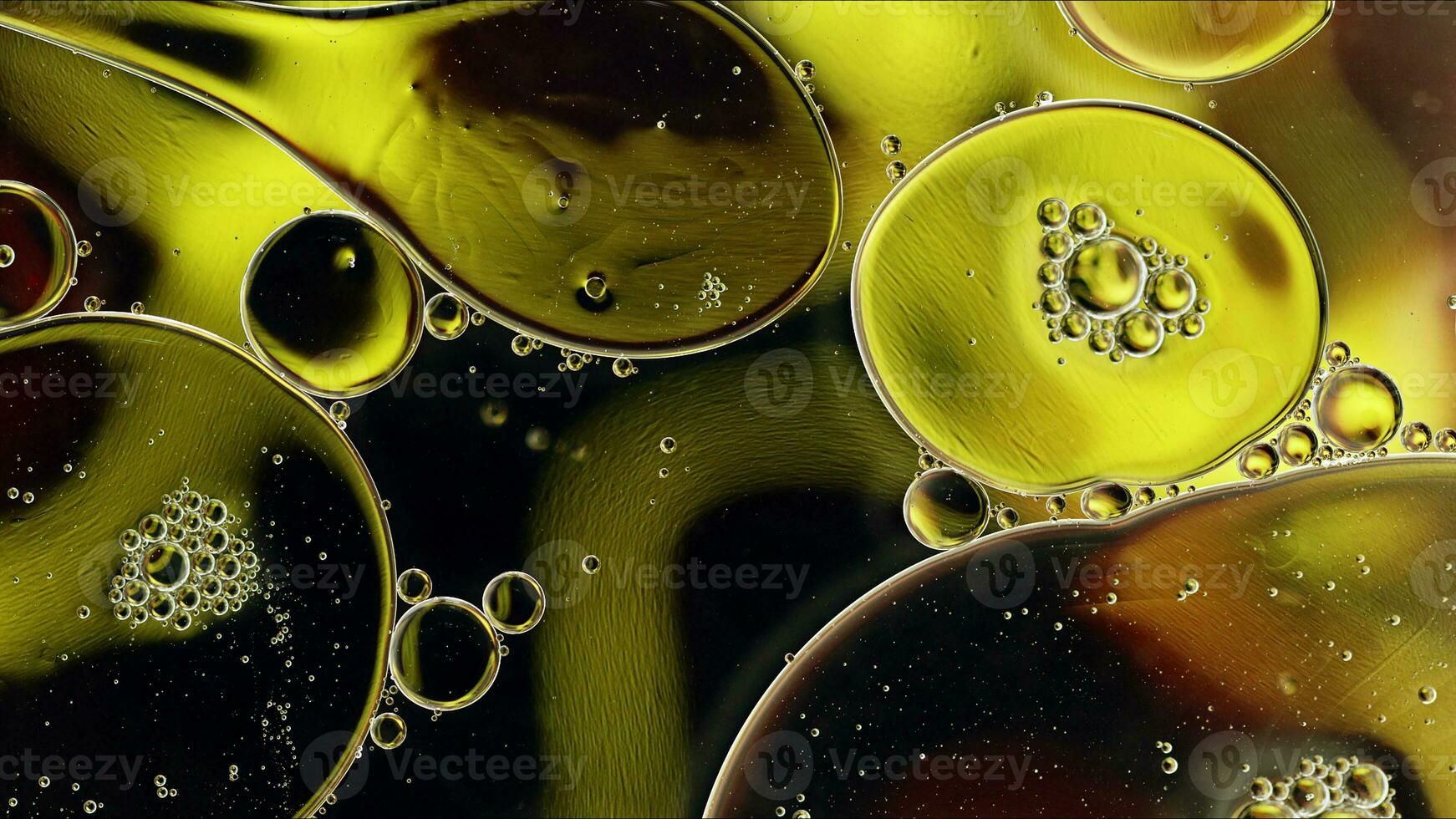 El aceite de comida colorido abstracto cae burbujas y esferas que fluyen en la superficie del agua foto