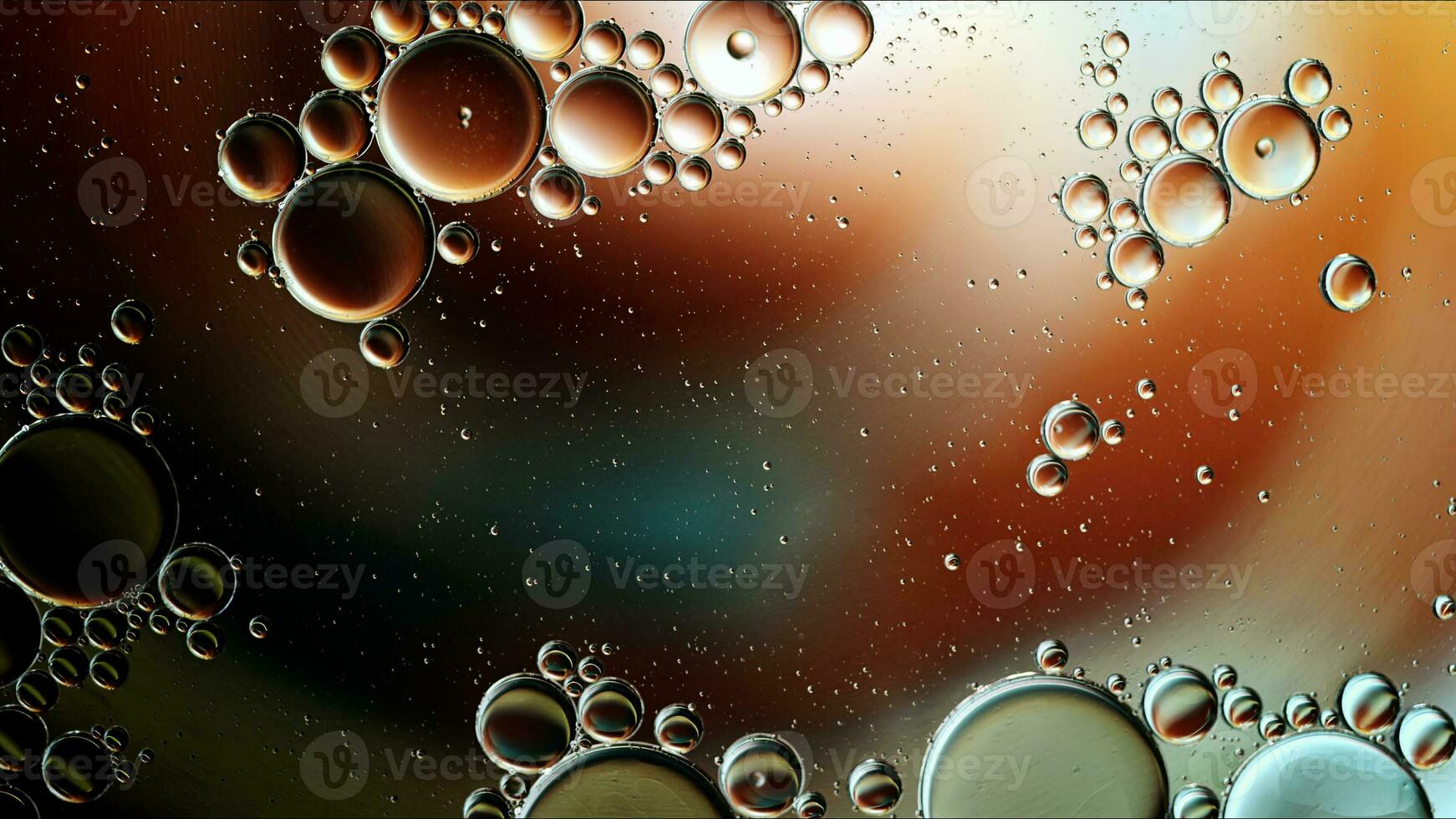 El aceite de comida colorido abstracto cae burbujas y esferas que fluyen en la superficie del agua foto