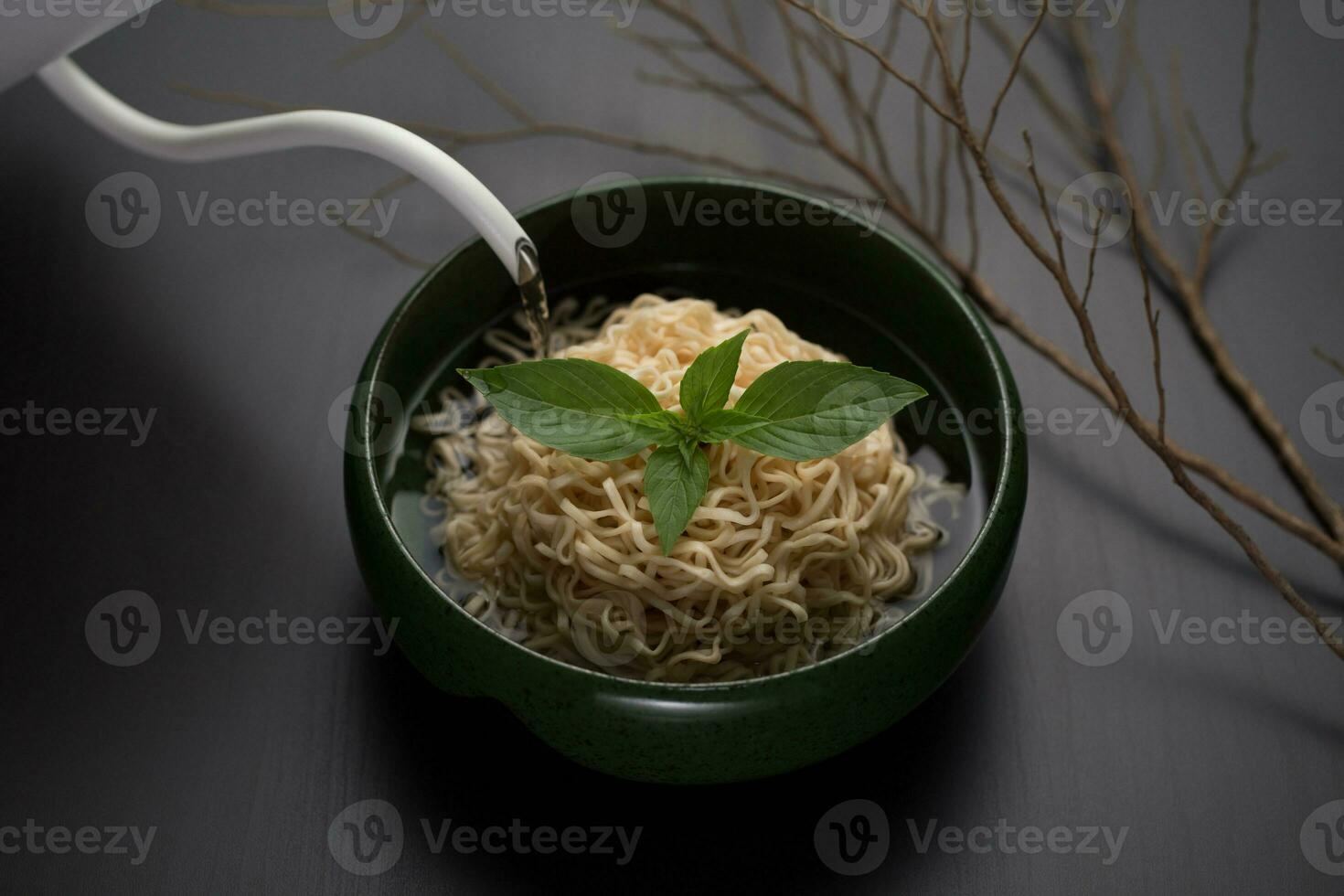 Instant noodles in a green ceramic bowl. photo