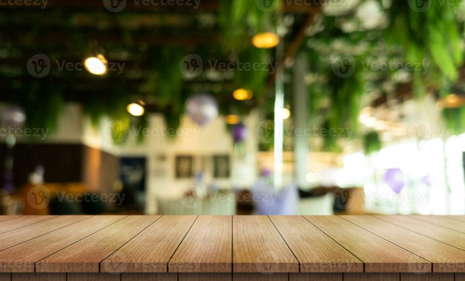 Empty wooden table top with lights bokeh on blur restaurant background. photo