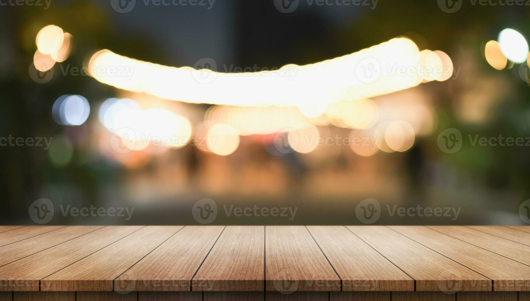 Empty wooden table top with lights bokeh on blur restaurant background. photo