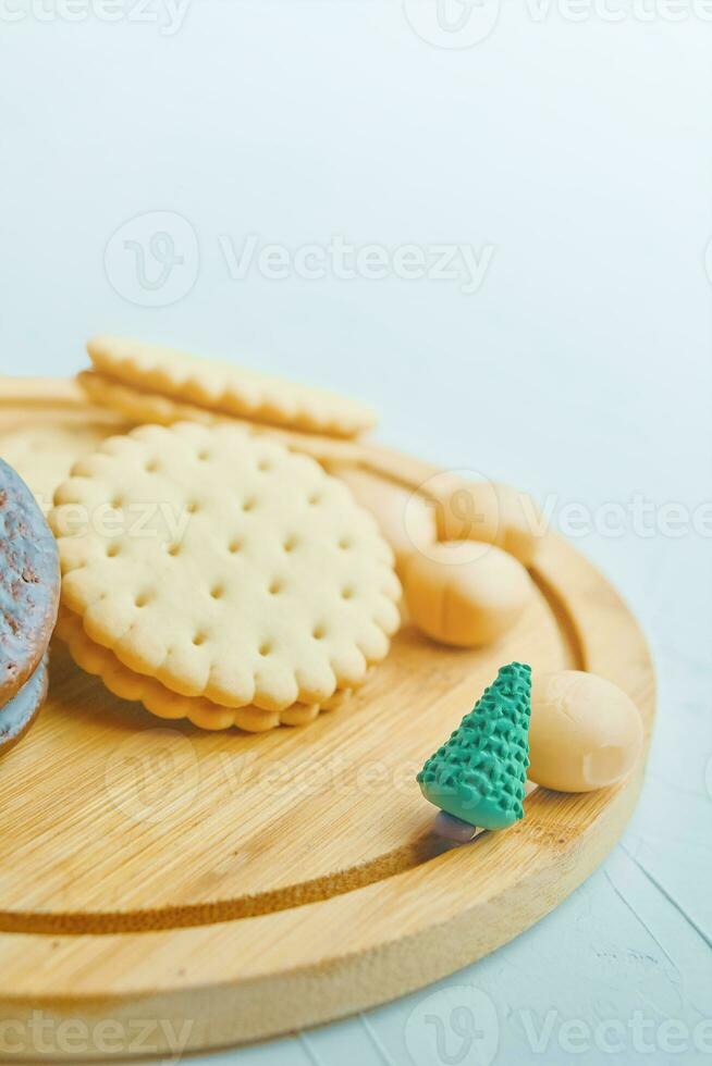 Cookies and candy on a wooden tray. photo