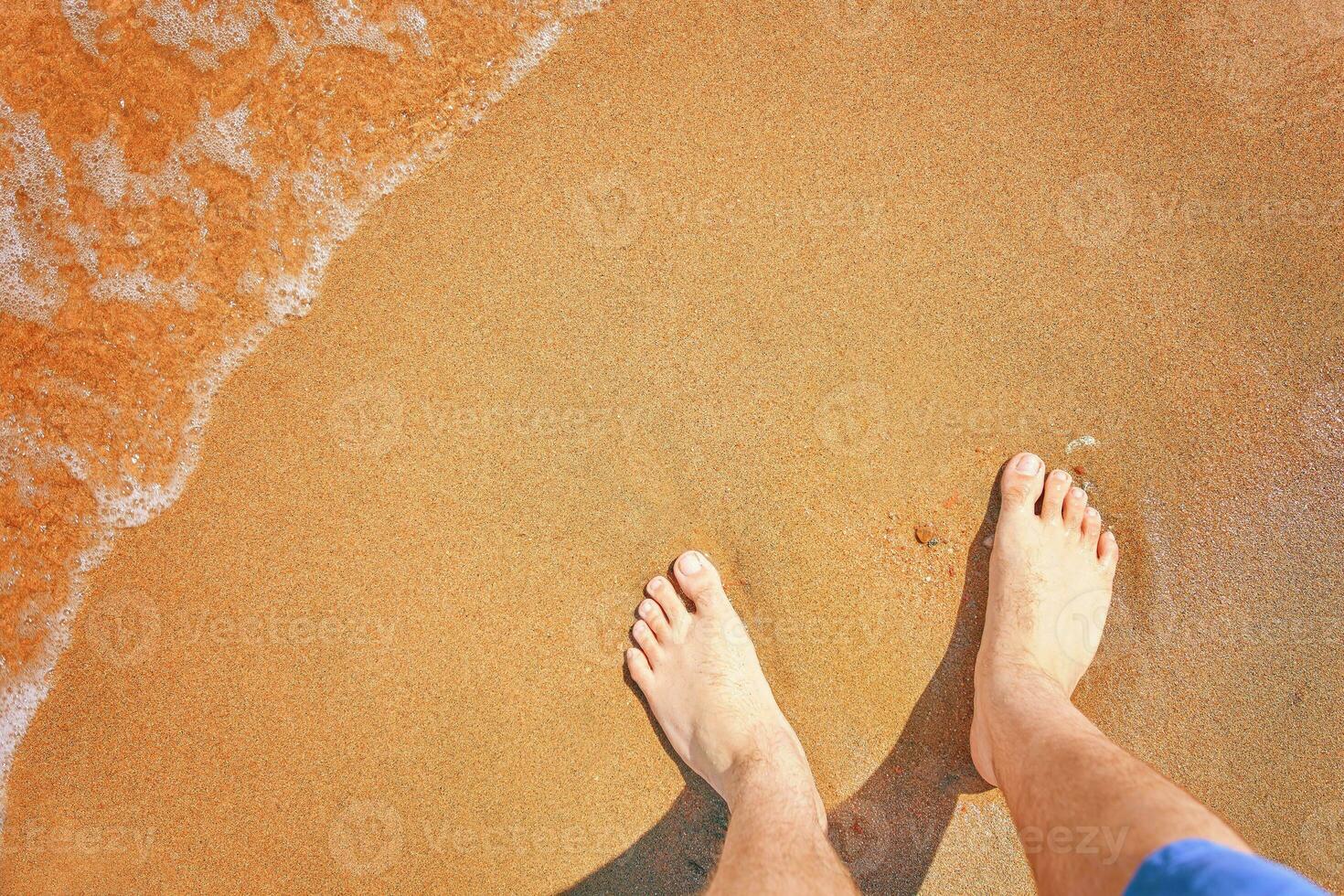 Men's feet on the beach. photo