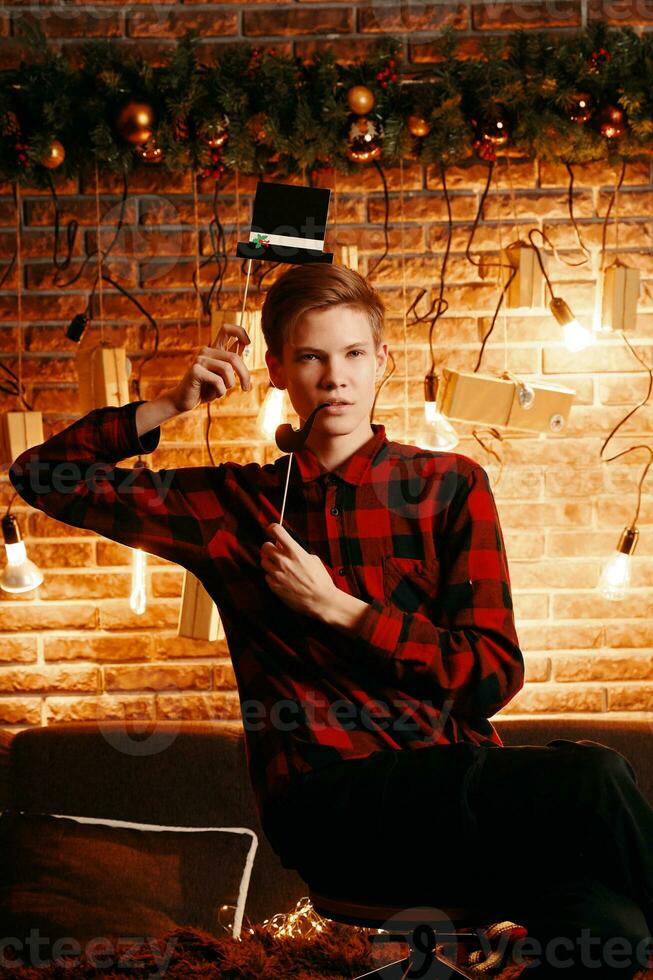 Handsome guy posing with top hat and pipe photo booth attributes.