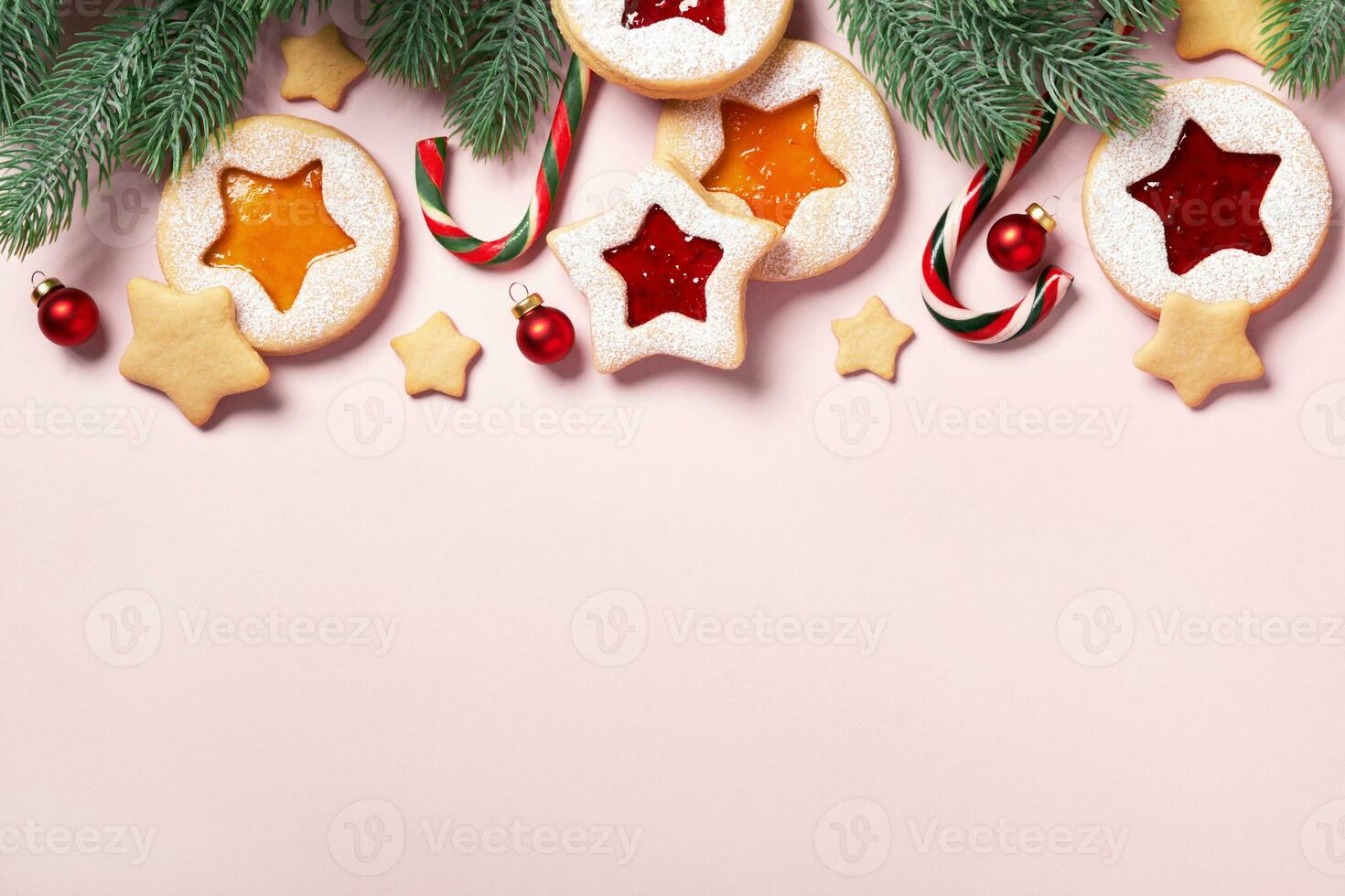 Christmas pink background with coniferous border and Linzer cookies. Festive pink background photo
