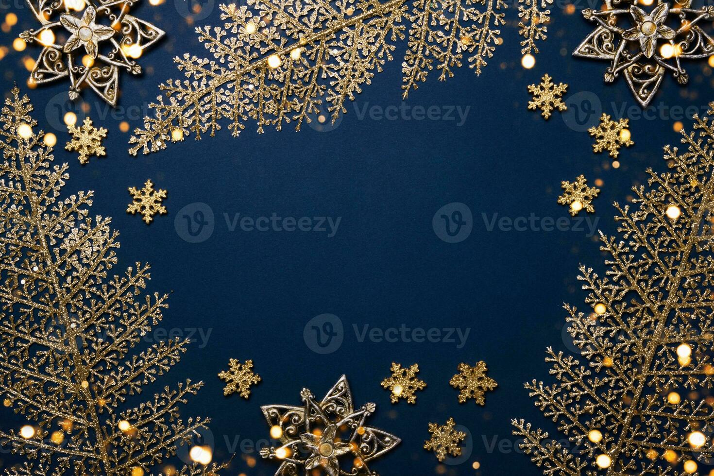 Christmas blue background. Shining golden pattern frame made of leaves, stars and snowflakes photo