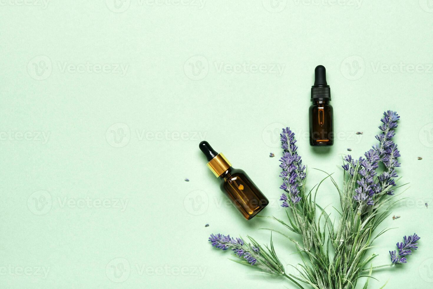 Lavender essential oil on mint green background. Aromatherapy treatment and Skincare spa cosmetics concept photo
