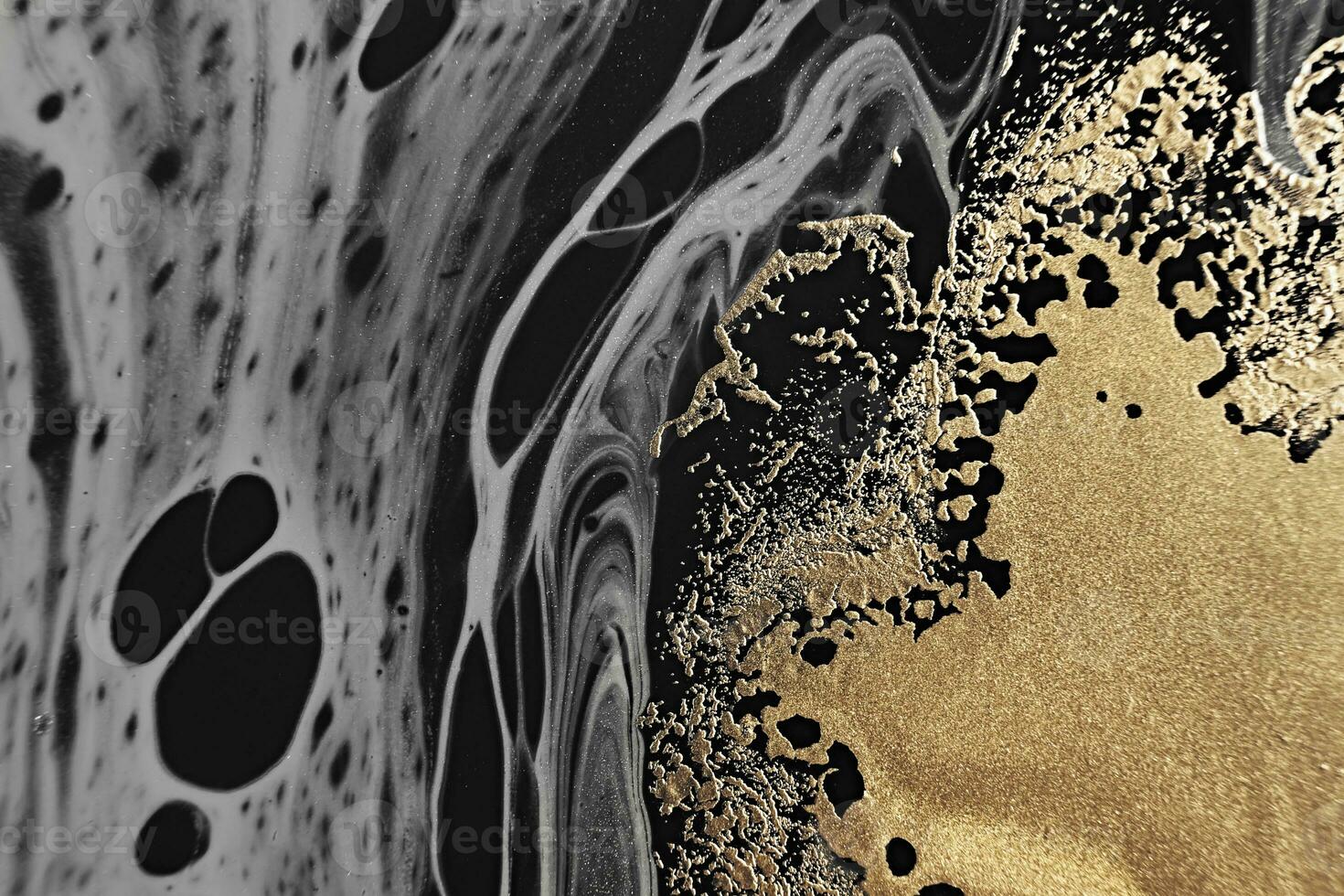 Fluid Art. Metallic gold and gray abstract waves on Black background. Marble effect background or texture photo