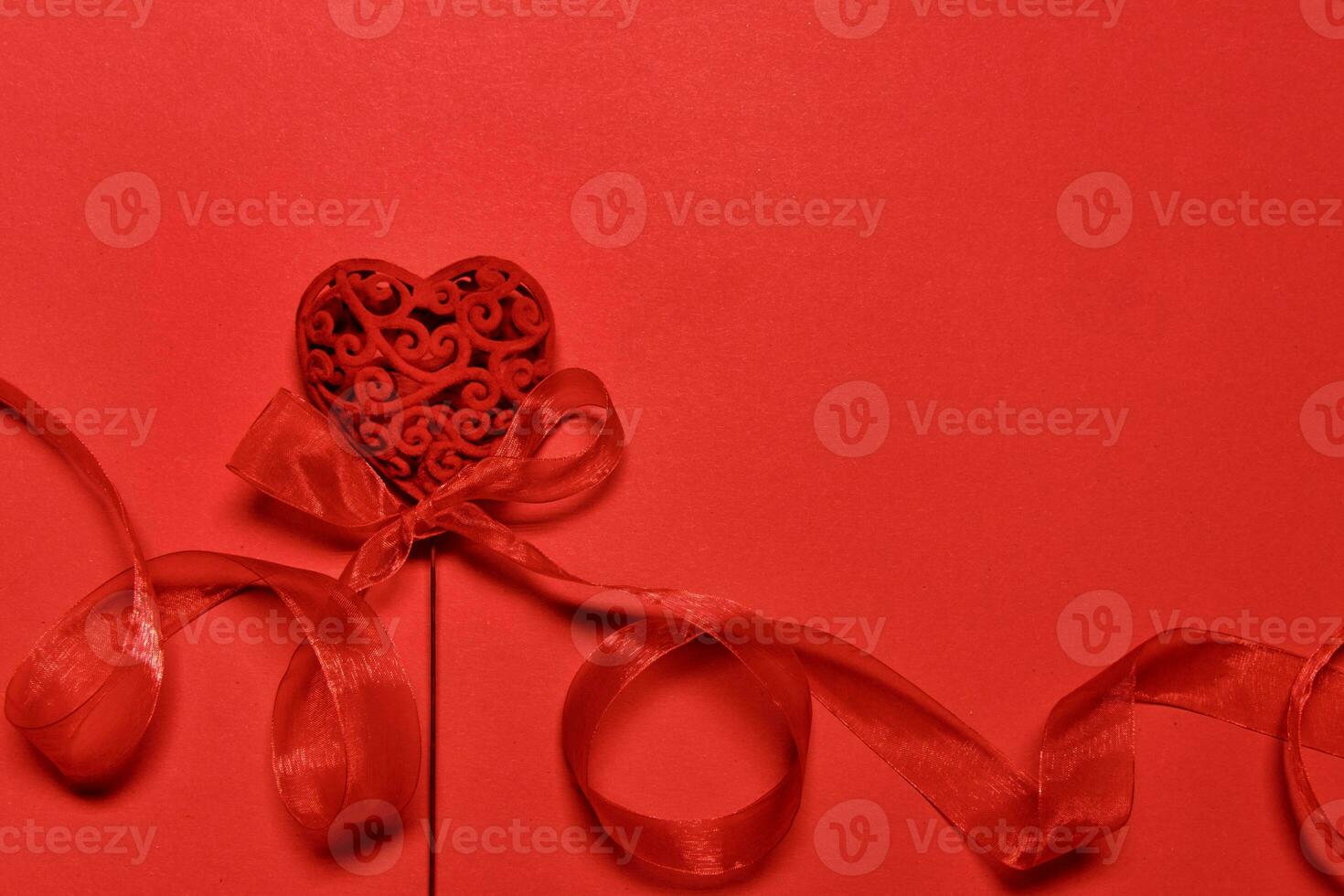 Valentine's day blank greeting card with openwork valentine heart with nylon ribbon. Red monochrome romantic background photo